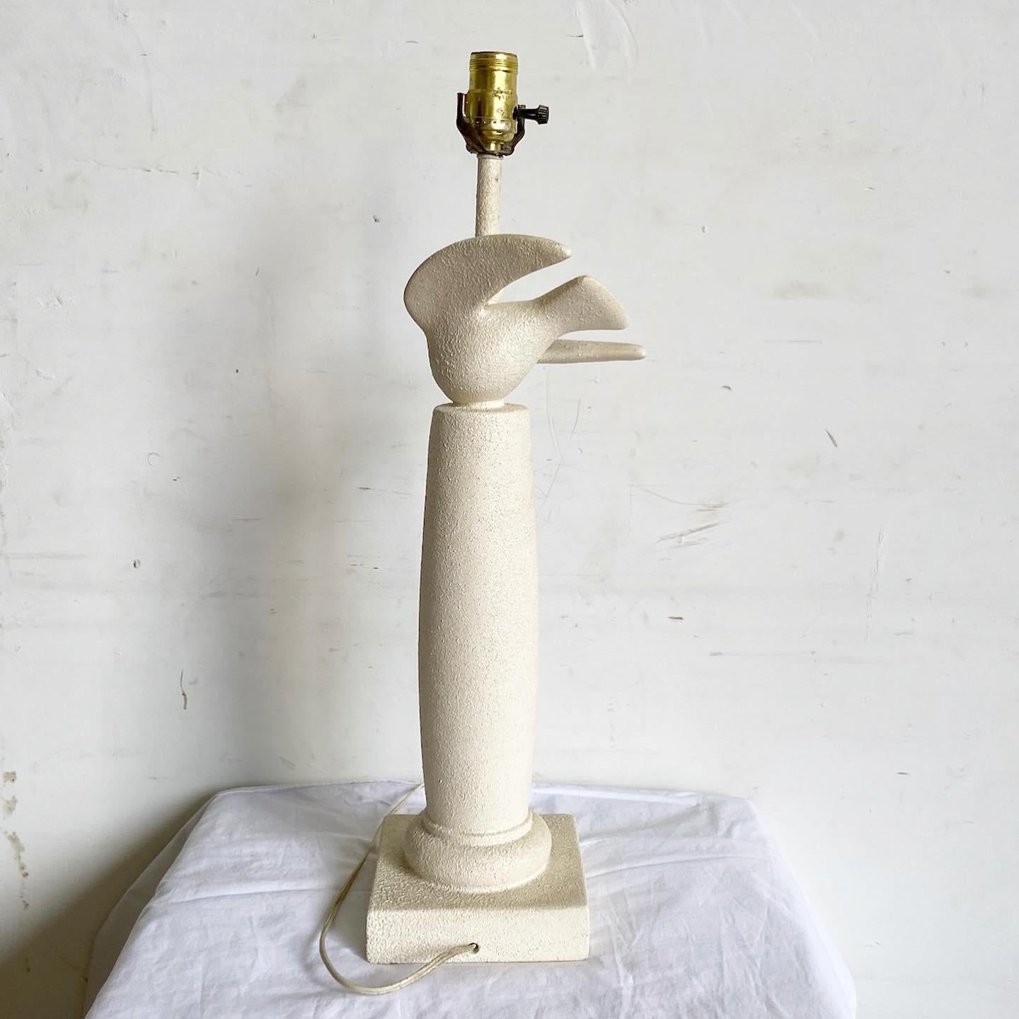 Illuminez votre espace avec l'élégance de la lampe postmoderne sculptée Dove. Son corps en plâtre texturé est orné d'une colombe gracieusement sculptée, symbole de la paix, qui prend son envol. La forme minimaliste associée aux détails complexes de