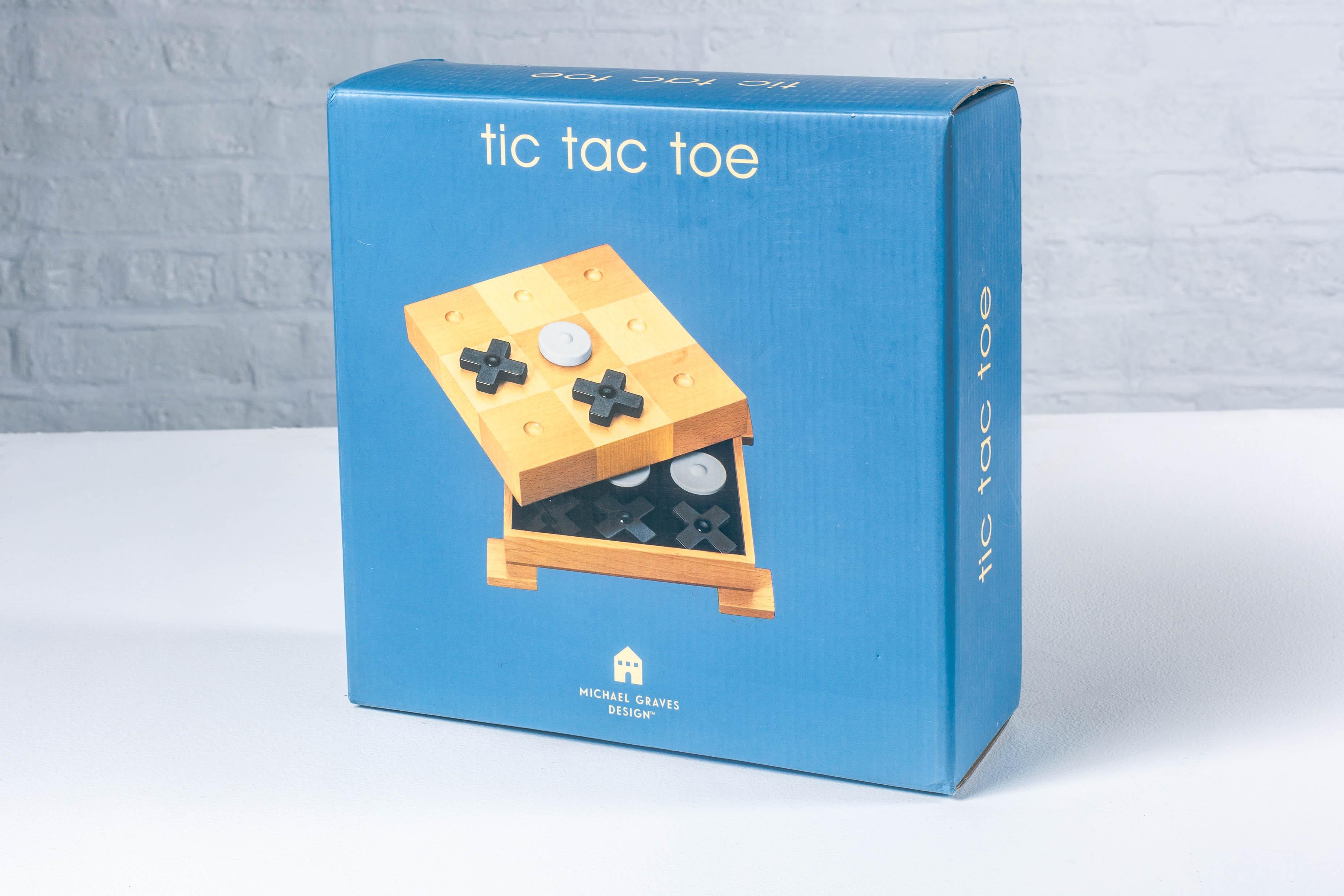 Dieses Tic Tac Toe-Brettspiel wurde von Michael Graves entworfen und hat einen eleganten und starken postmodernen Stil. Das Schachbrett steht auf 4 quadratischen Füßen und verleiht dem Spiel das Aussehen eines Denkmals auf Sockeln. Das Brett dient