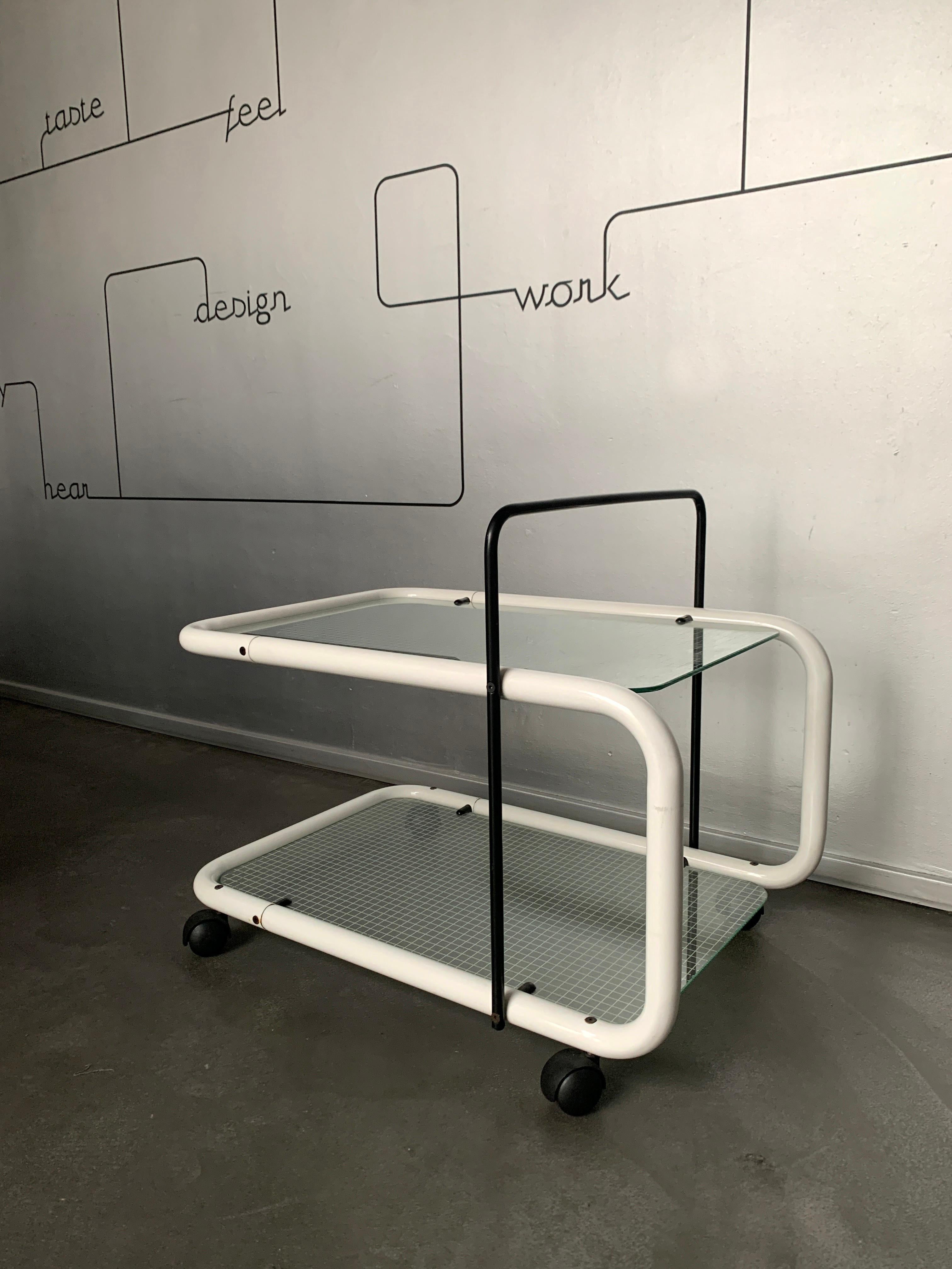 Black White Postmodern Serving Trolley with Quaderna Pattern.

In a minimalist, efficient style typical of 80s design, this serving trolley has a highly graphic silhouette. 

In black and white, it is made from bent steel tubes and transparent glass