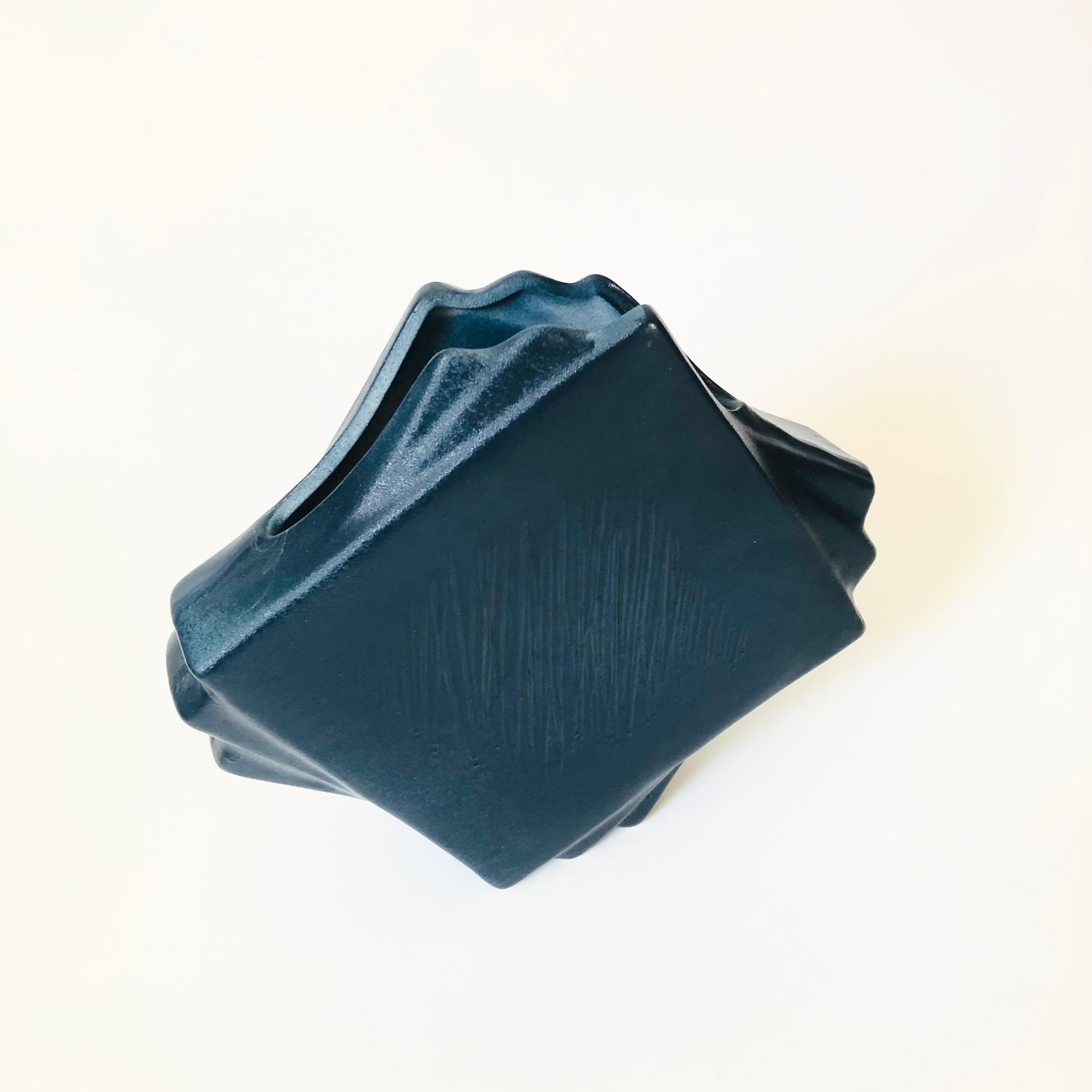 A vintage ceramic vase, made in Japan by Toyo. Great postmodern design resembling overlapping squares. Textured design on one side. Finished in a dark blue glaze.


