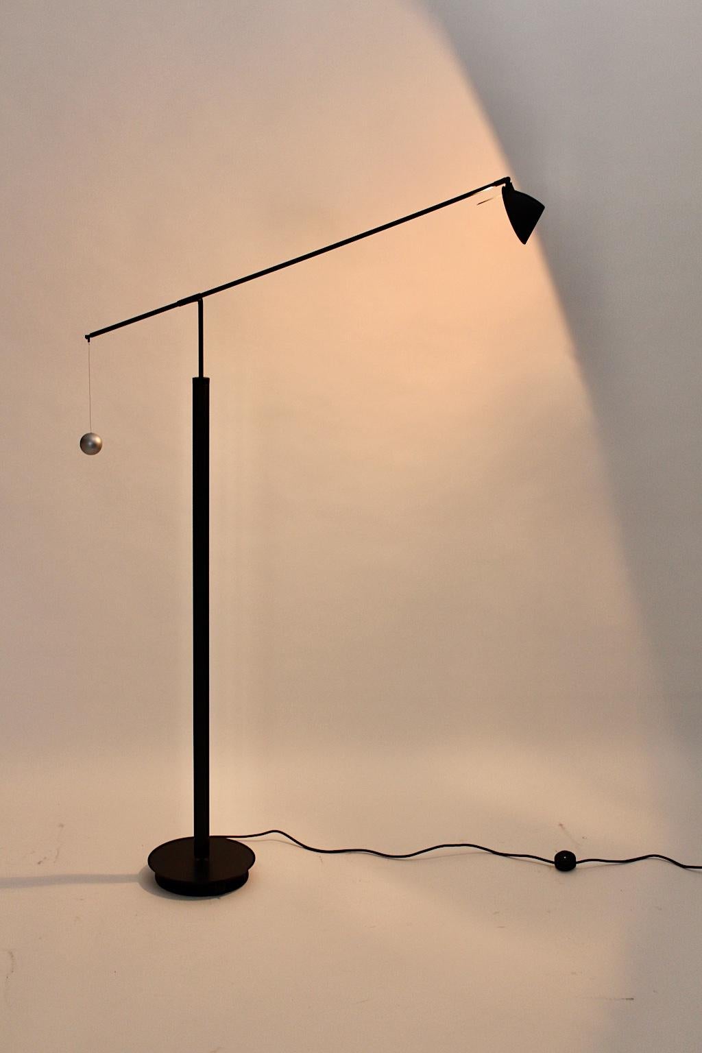 A Postmodern vintage black floor lamp, which was designed by Carlo Forcolini 1989 for Artemide, Italy.
It is labeled underneath the base: Artemide Milano Modelo Nestore Lettura Design Carlo Forcolini 
Made in Italy 220 V.
The black metal