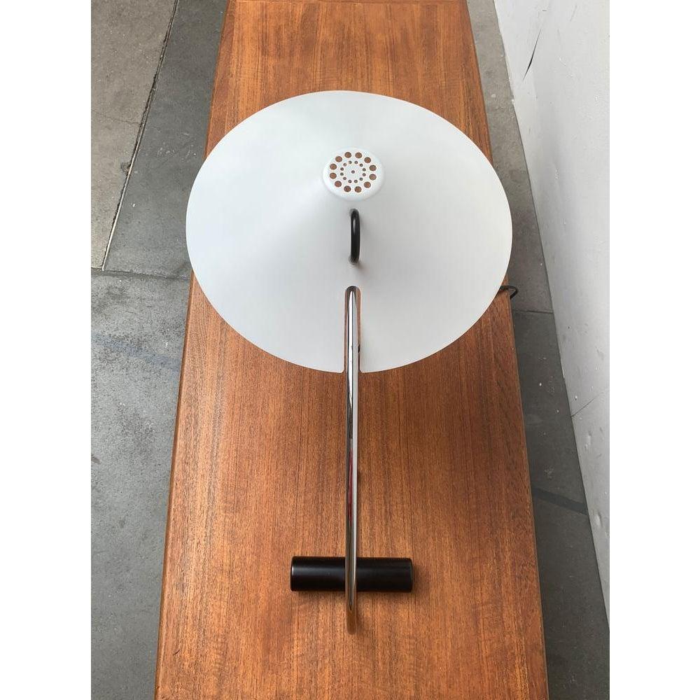 Rara lámpara de mesa de Artimeta en negro, blanco y cromo.

Un diseño elegante con un pie minimalista y elementos posmodernos. Llama la atención el brazo ancho y curvado, que se estabiliza sobre un sencillo cilindro negro. En la parte superior hay