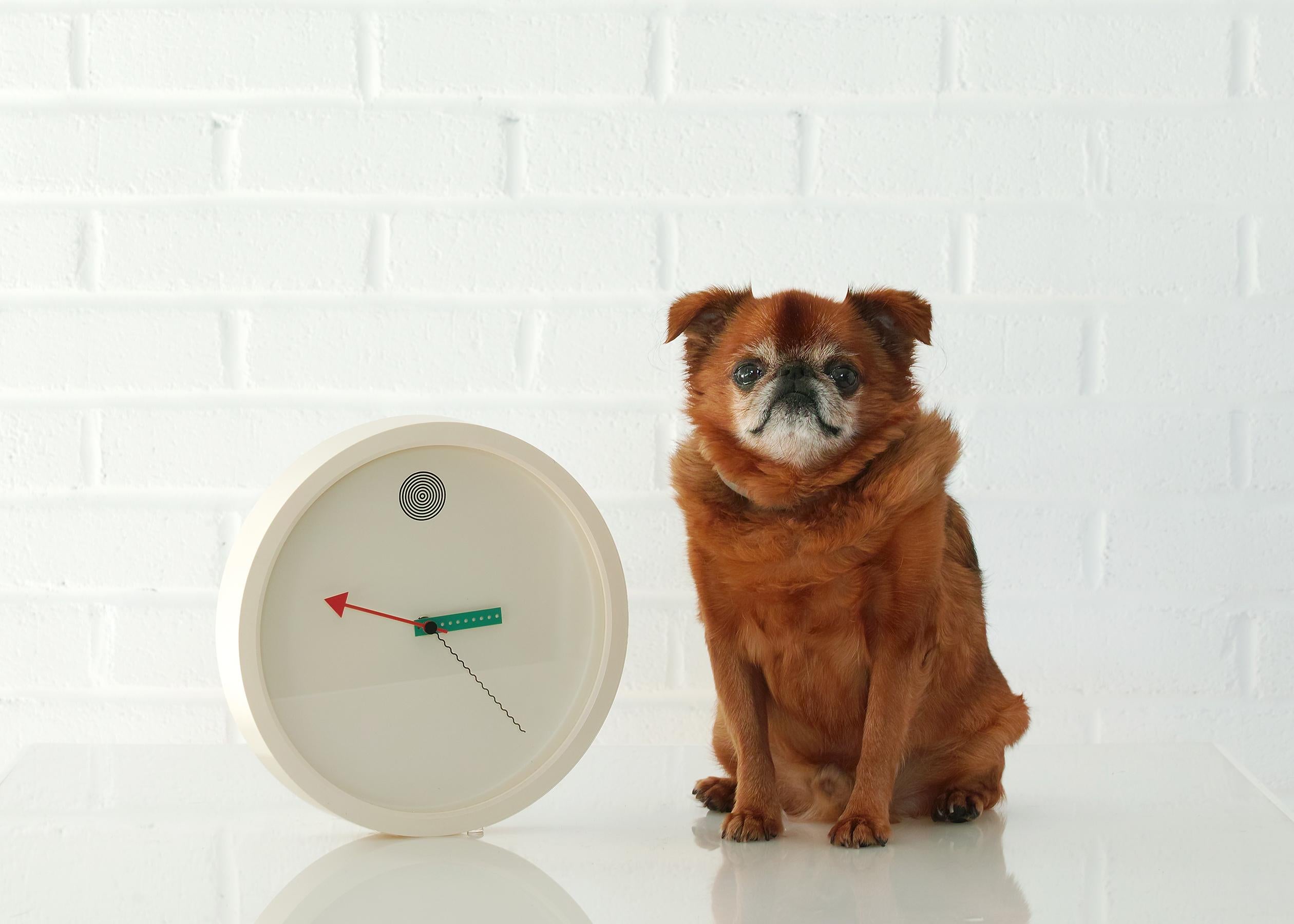 For your consideration is this 1980s Japanese post-modern wall clock by Shohei Mihara for Wakita. It features an ivory toned background and frame, 12th hour marked by radiating black circles, a perforated green rectangular hour hand, a red arrow