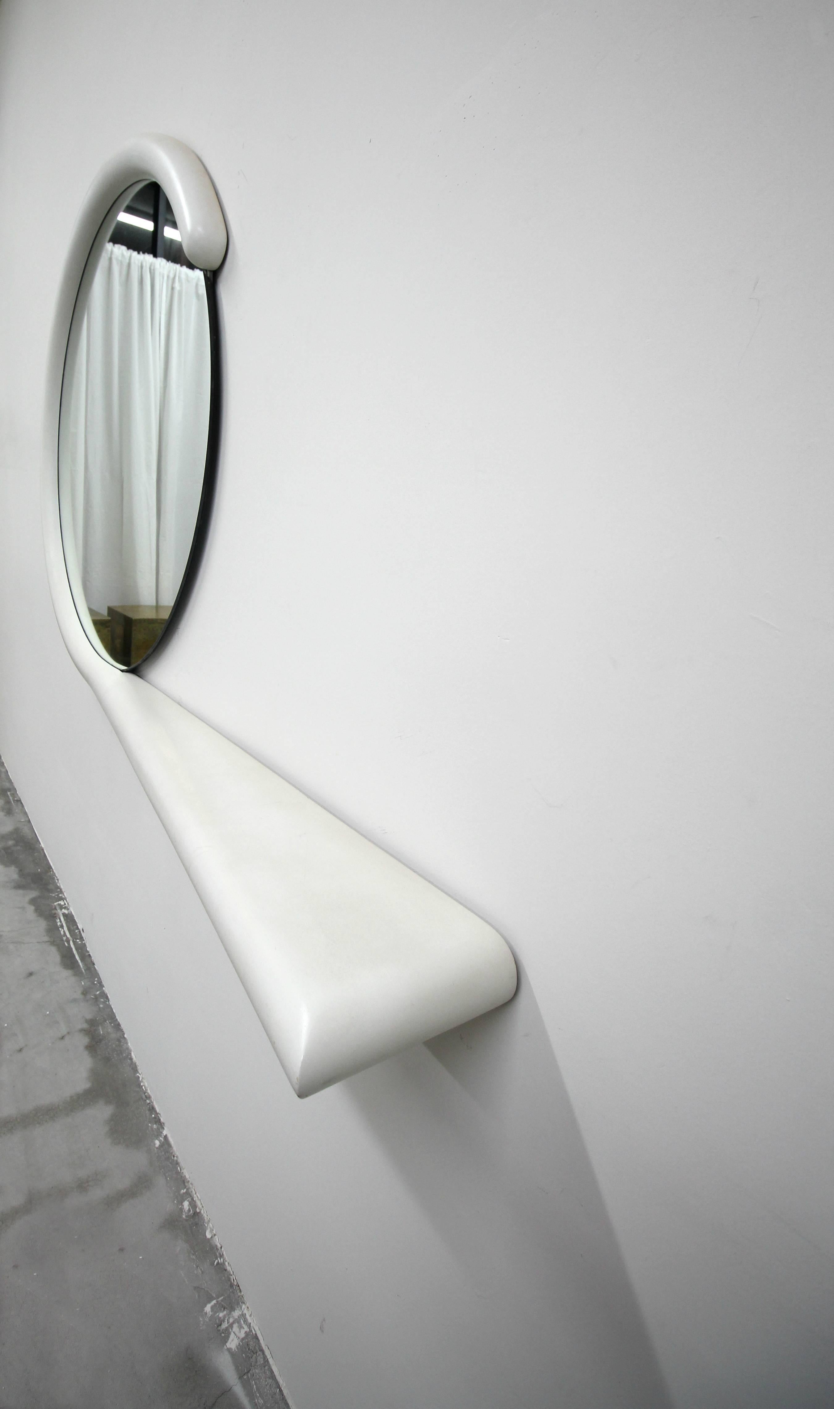 Unique Postmodern, hanging wall mirror with attached console shelf by Jay Spectre. Has very modern appeal that can mesh well with so many decors.