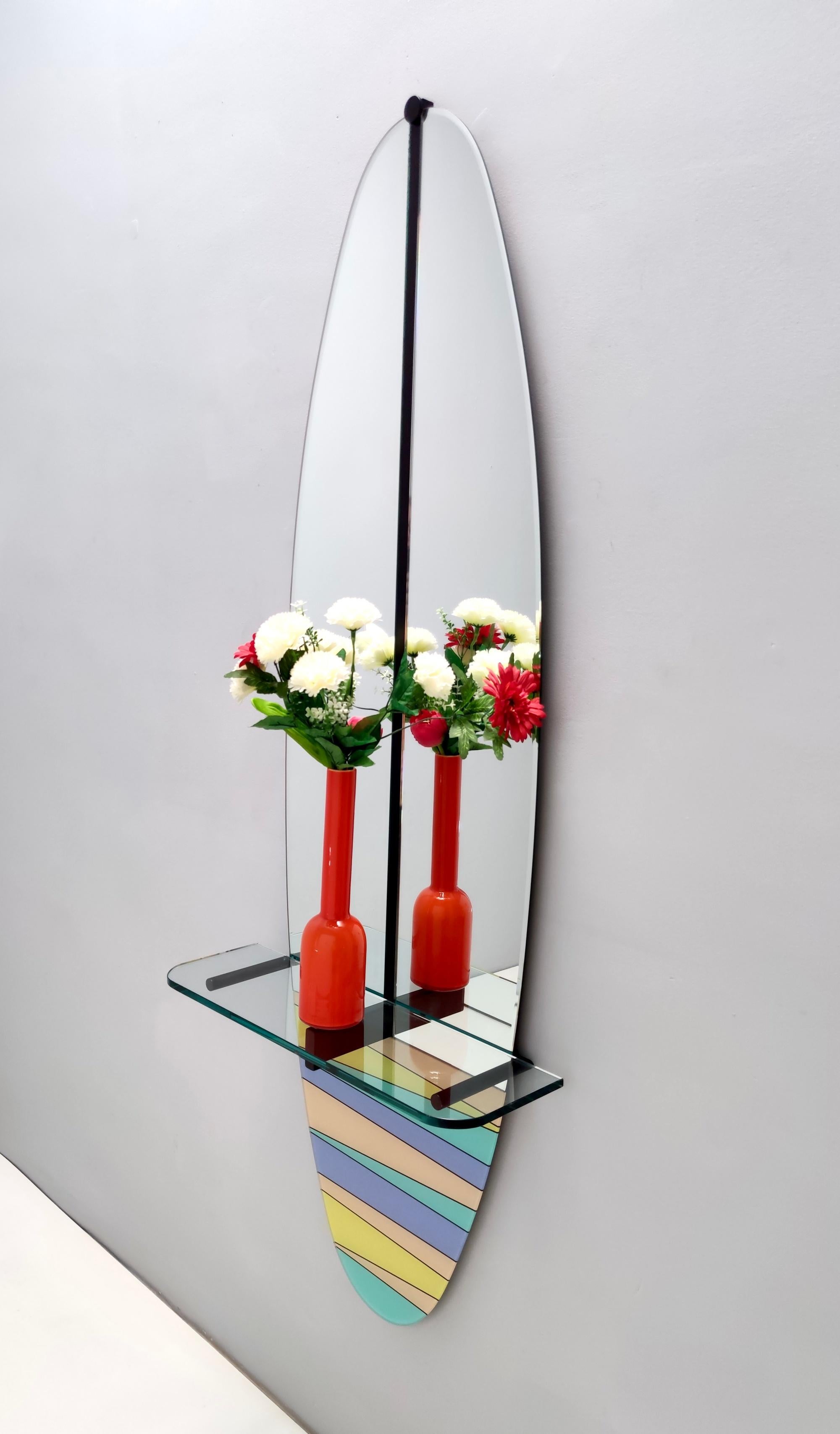 Made in Italy, 1980s.
This mirror features a multi-layered beech back, a varnished metal frame, a crystal top and a multi-color serigraphed mirror.
It might show slight traces of use since it's vintage but it can be considered as in excellent