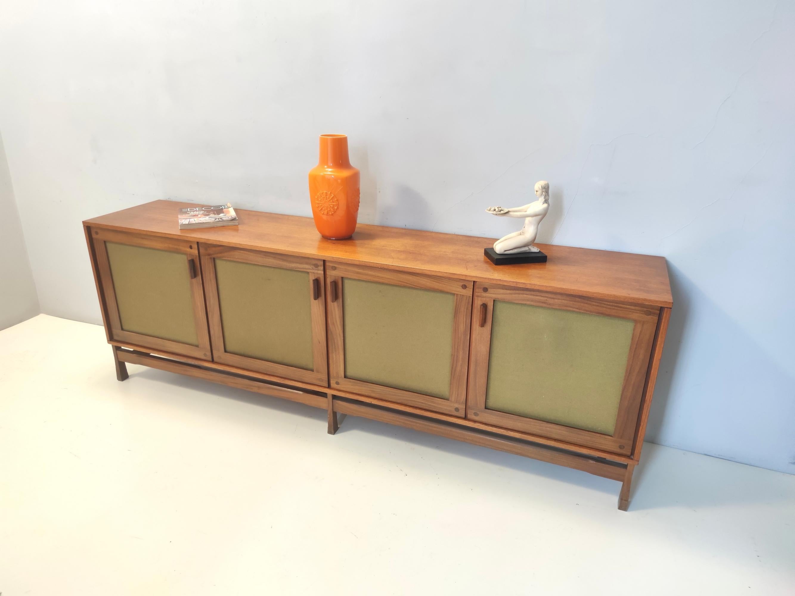Made in Pavia, Italy, 1970s. 
This sideboard is made in walnut and features two drawers (one is missing). 
The former owner used two internal parts with no shelves, but on request and with no additional cost, we can create two glass shelves. 
It is