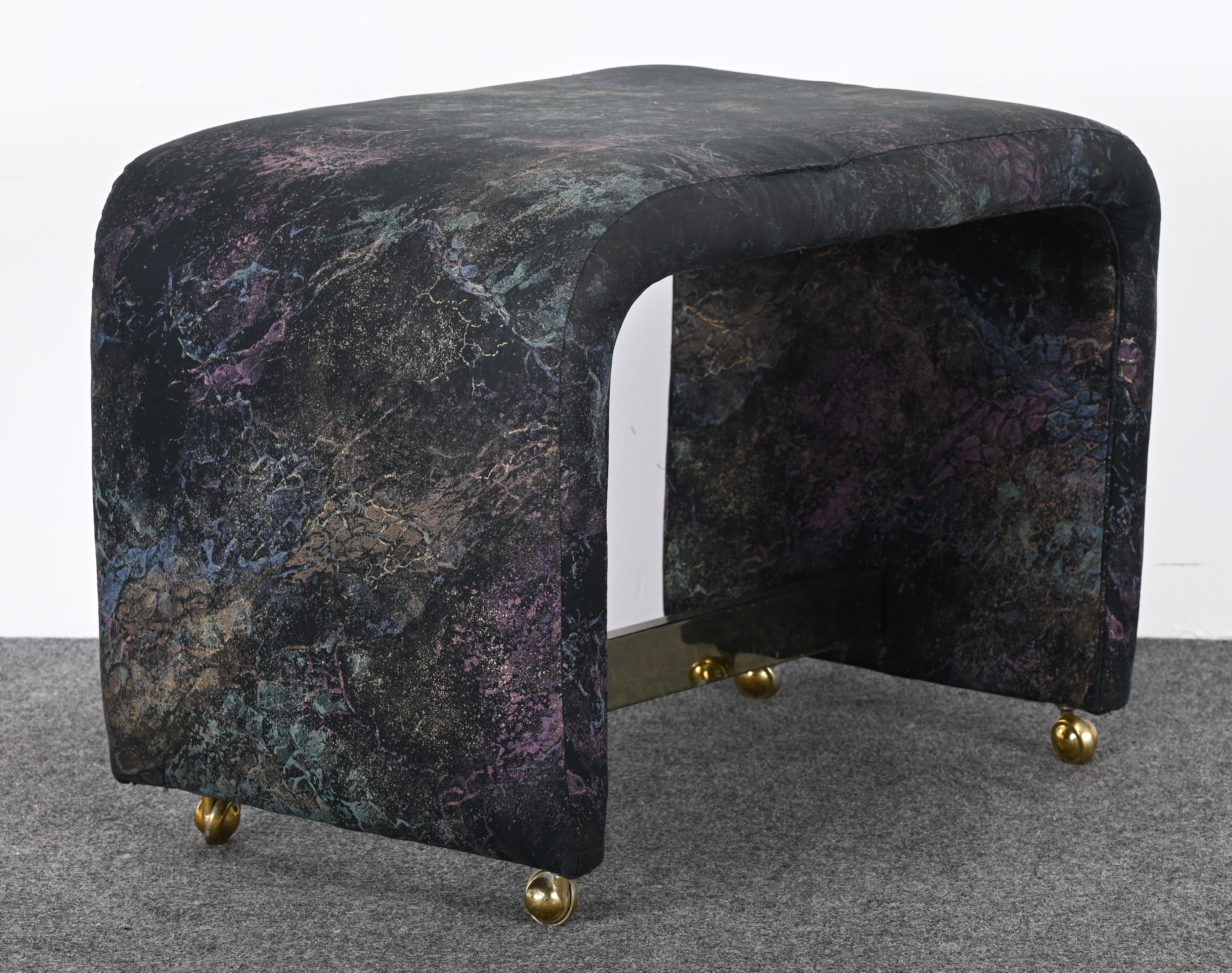 A chic Waterfall Vanity Bench or Bench designed by Milo Baughman for Thayer Coggin, 1980s. This Post-Modern bench has a chrome stretcher base and brass roller feet. It would look great in a bedroom or living room. The bench has original fabric, new