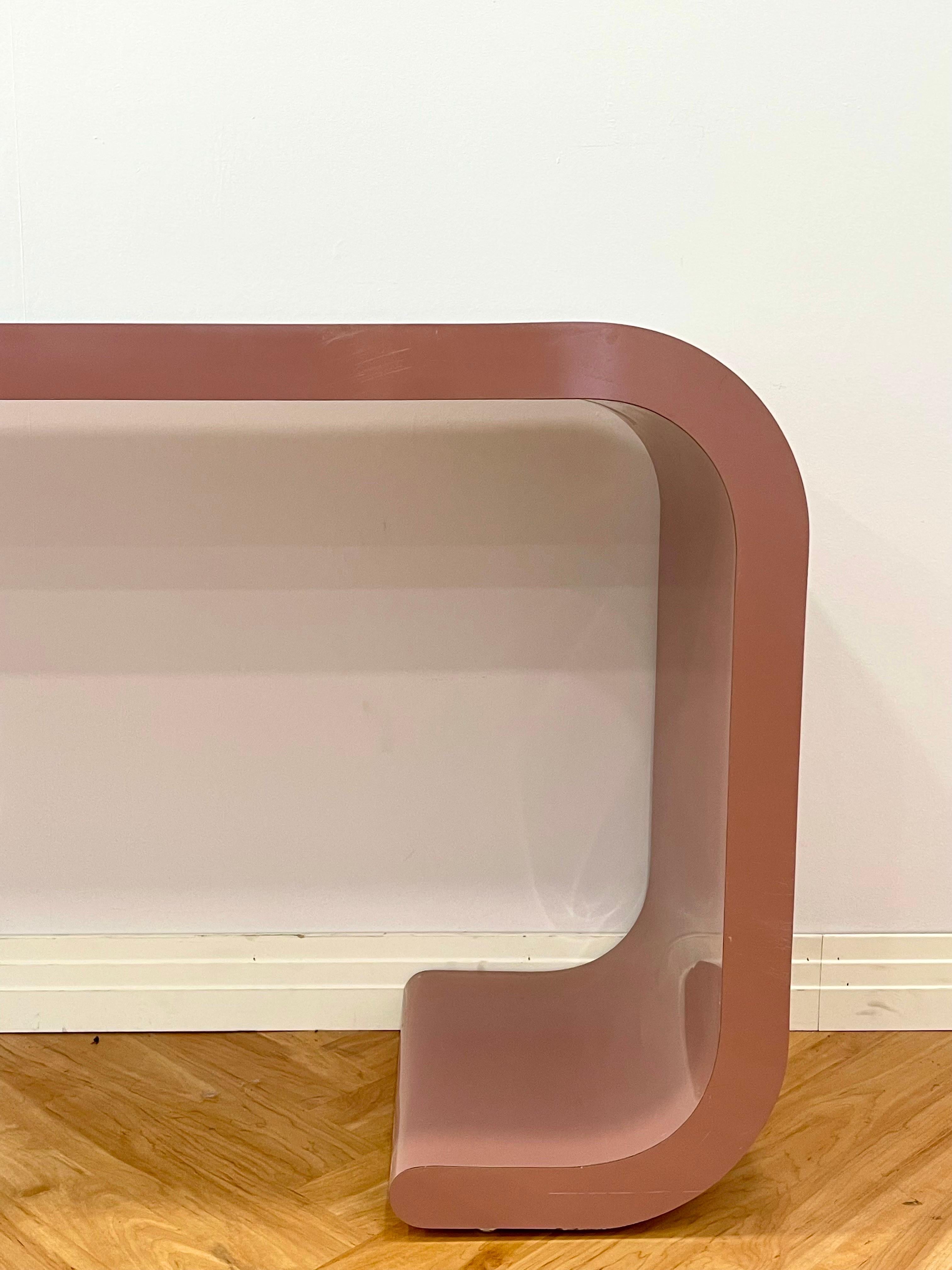 Custom postmodern waterfall console table in mauve laminate. Good condition with minor scratches and scuffing.