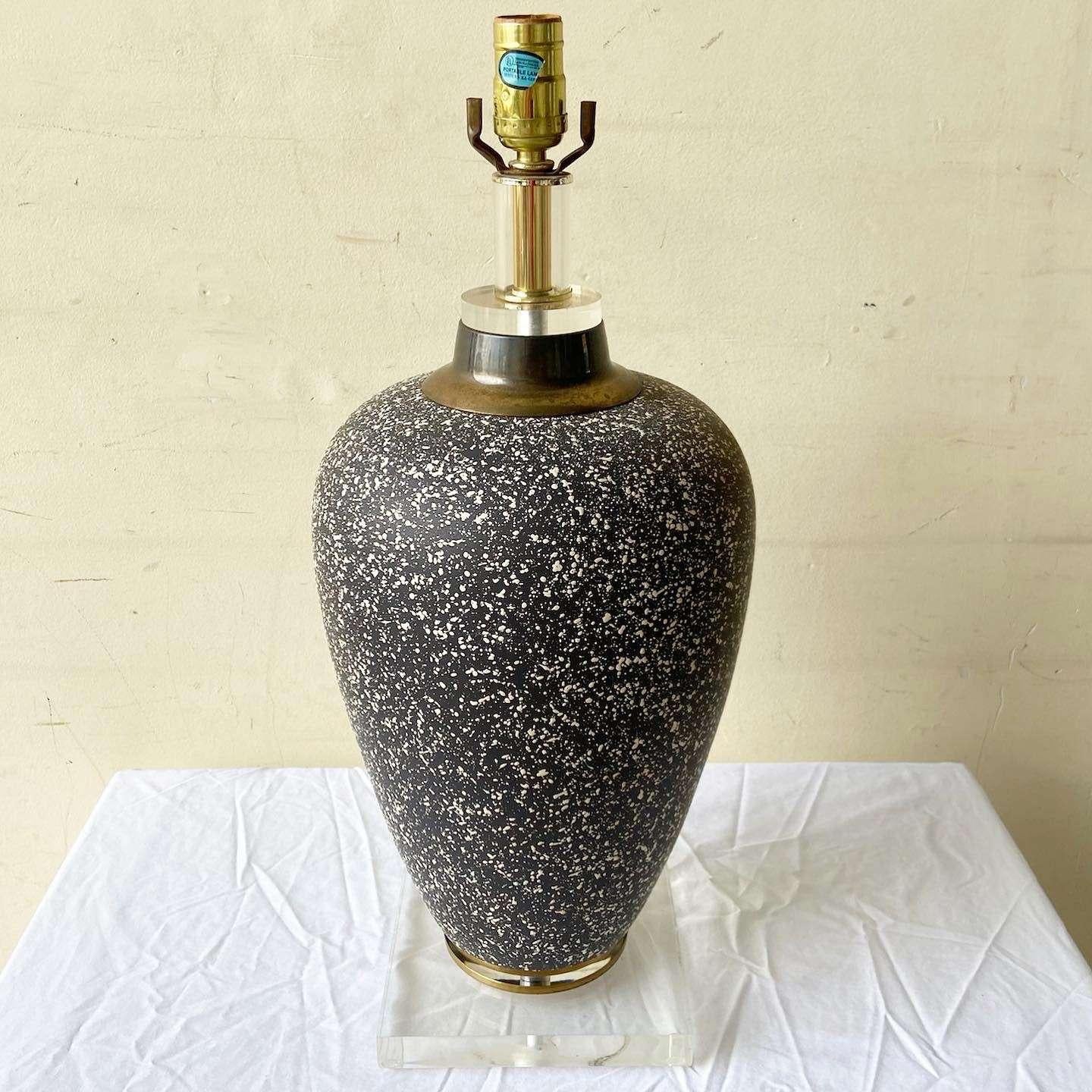 Exceptional vintage Postmodern ceramic table lamp. Features a black and white speckled finish with a lucite base.
