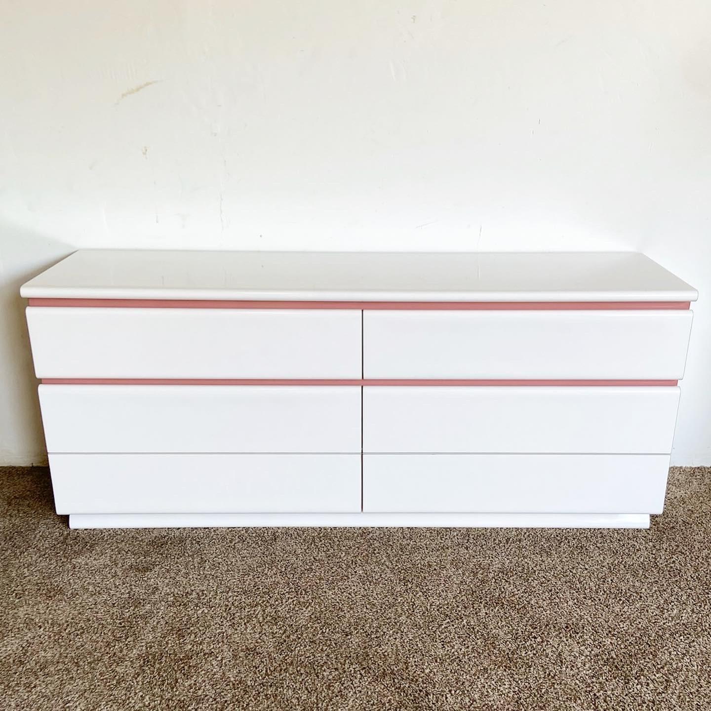 Wonderful vintage postmodern dresser with 6 large drawers. Features a white and mauve pink lacquer laminate.

Mirror measures 49.25”W, 1.5”D, 32.5”H.
