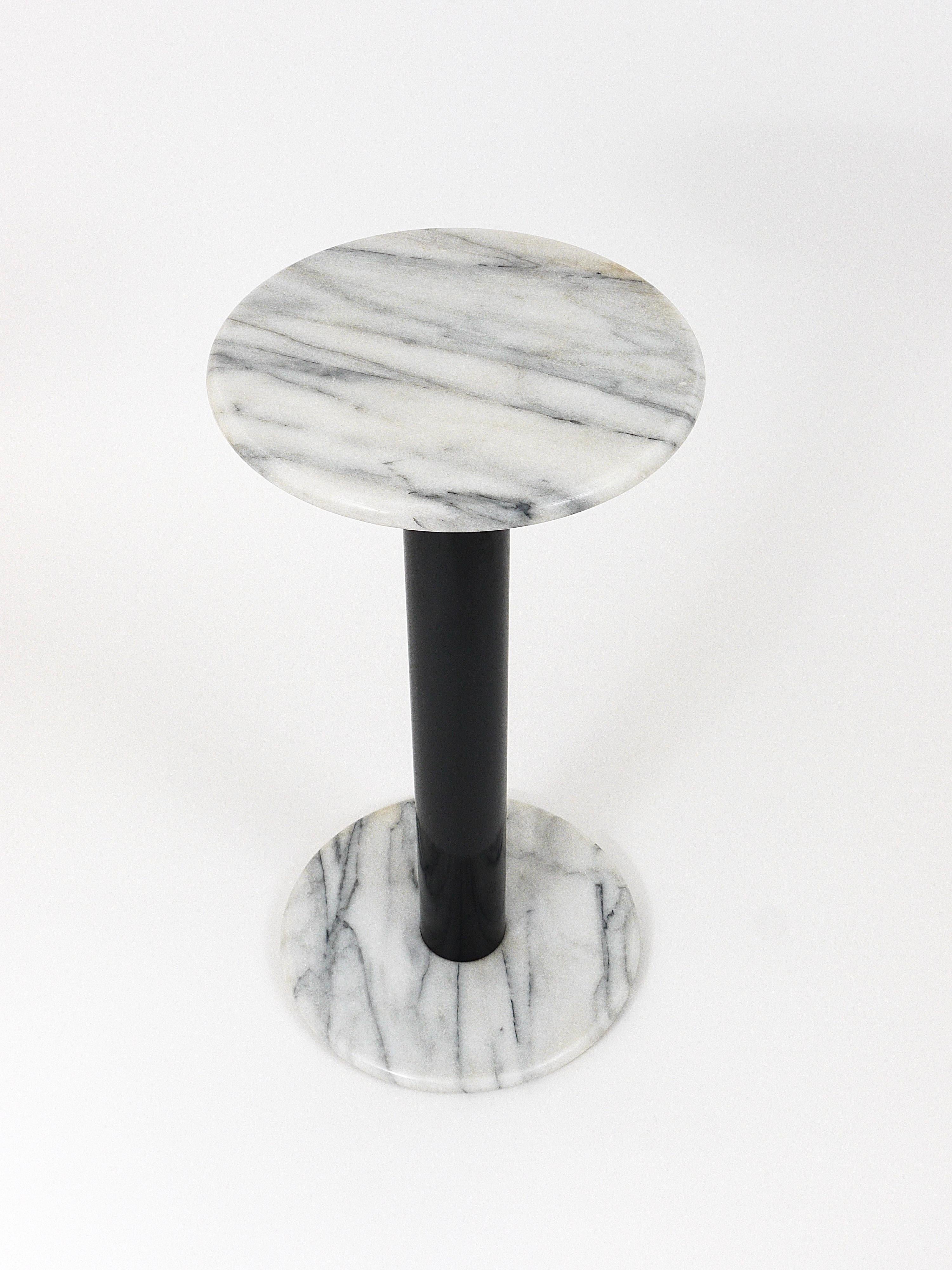 A beautiful Italian post-modern pedestal / flower table / plant stand with a white marble base and top and a black metal stem. Made in Italy in the 1980s, in good condition, with marginal signs of age.