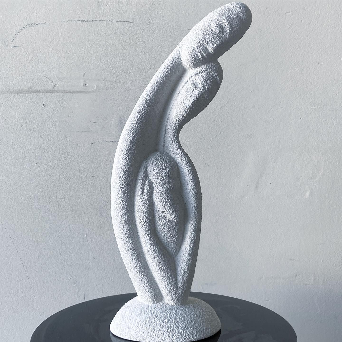 Beautiful White Postmodern ceramic sculpture depicting two people hugging in a curved form.
