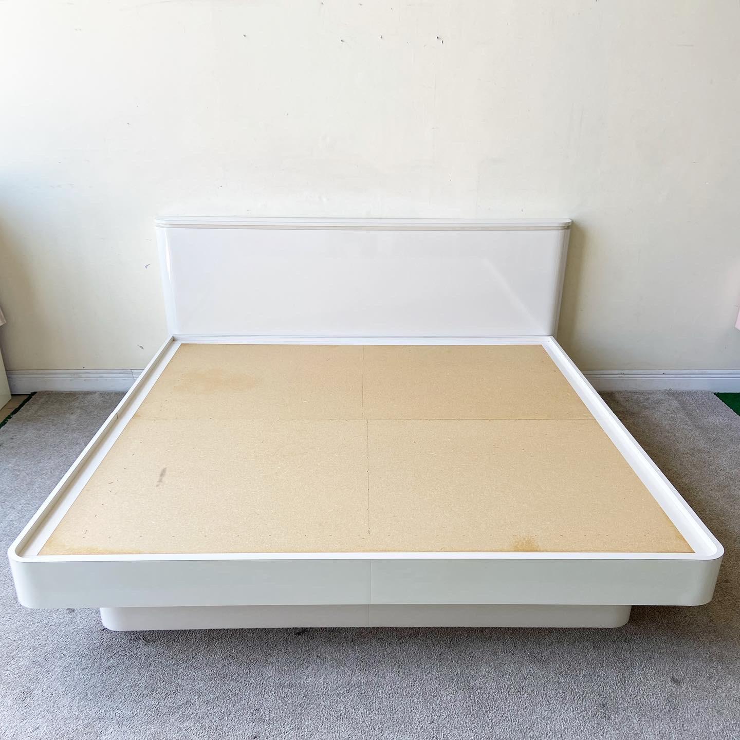 Exceptional postmodern king size platform with headboard. Bed features a white lacquer laminate with beautiful curved edges.

Headboard measures 80”W, 5”D, 36”H
Platform bed measures 77.5”W, 80.5”D, 14.25”H.