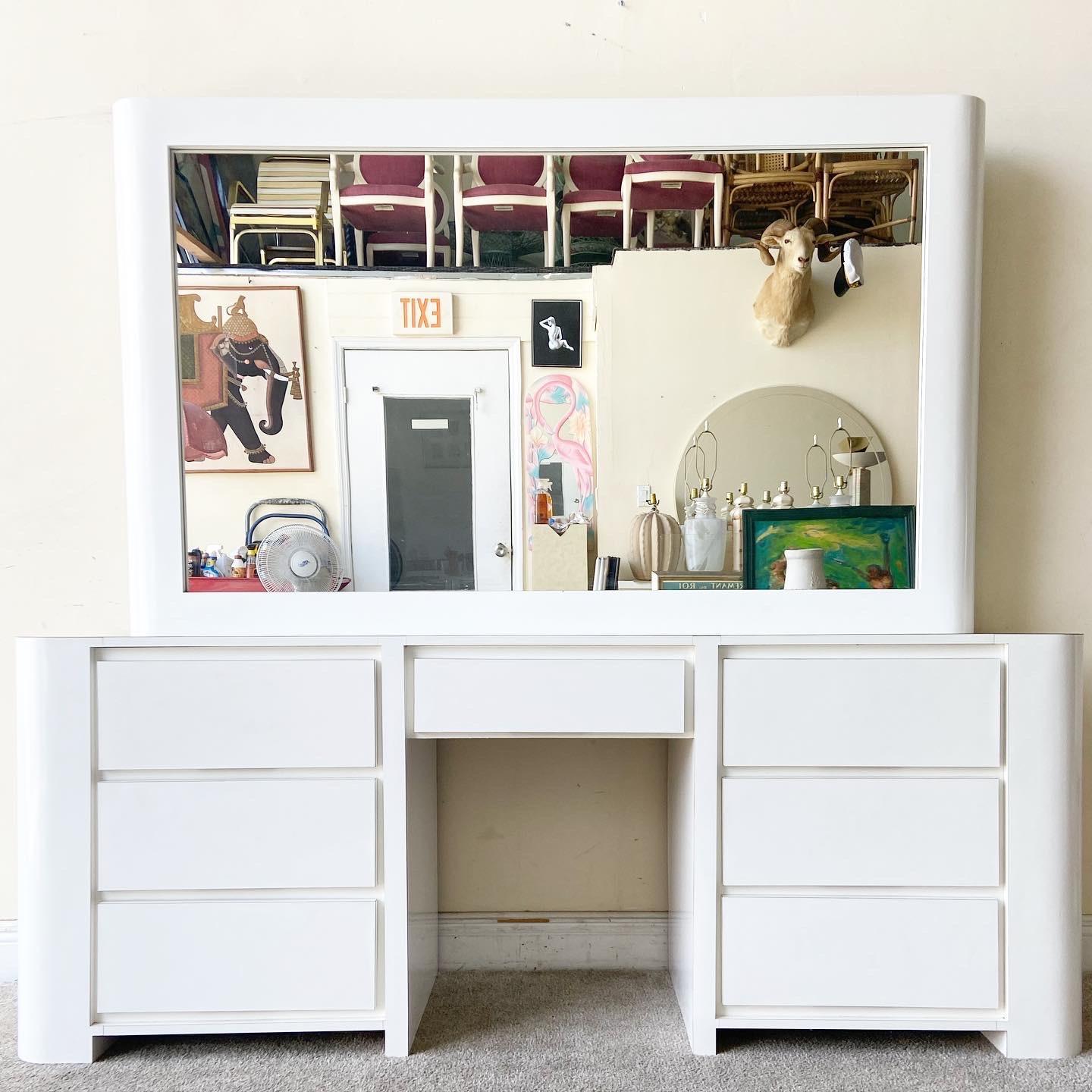 Exceptional postmodern 1980s vanity desk/dresser. Features an oversized mirror with white lacquer laminate and 7 spacious drawers.

Dresser measures 73” W, 18.5” D, 28.5” H
Mirror measures 68” W, 5” D, 41” H
Stool measures: 13