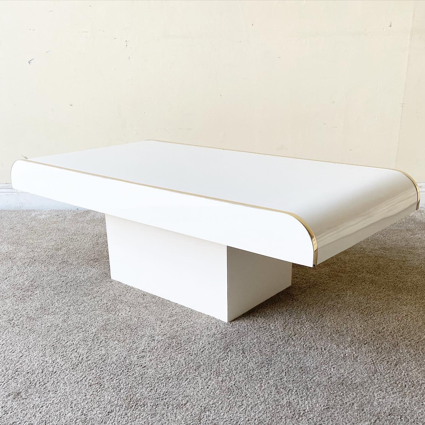 Incredible 1980s postmodern waterfall coffee table. Rectangular table features a white lacquer laminate with gold edges.

Additional Information:
Material: Laminate, Wood
Color: Gold, White
Style: Postmodern
Time Period: 1980s
Place of