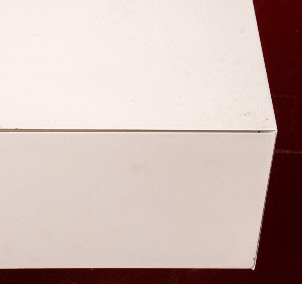 Escritorio credenza postmoderno de laminado blanco, de forma rectangular alargada, con cuatro cajones en la sección superior, sobre una sección inferior en voladizo con dos cajones cortos y un soporte. Medidas: 31