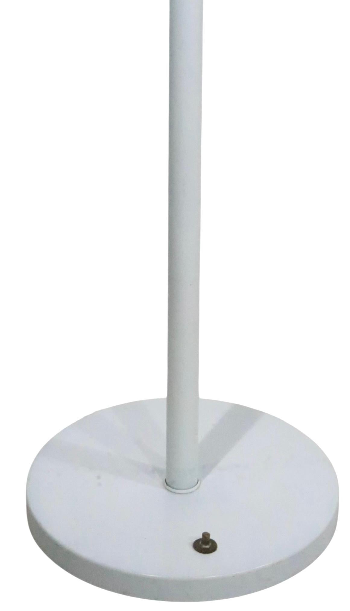 Lampadaire torchère vintage chic blanc sur blanc, design attribué à Walter Von Nessen, fabricant attribué à Nessen Studios. La lampe est dotée d'un sommet conique Top-Light, qui est perforé pour permettre à plus de lumière de s'échapper de