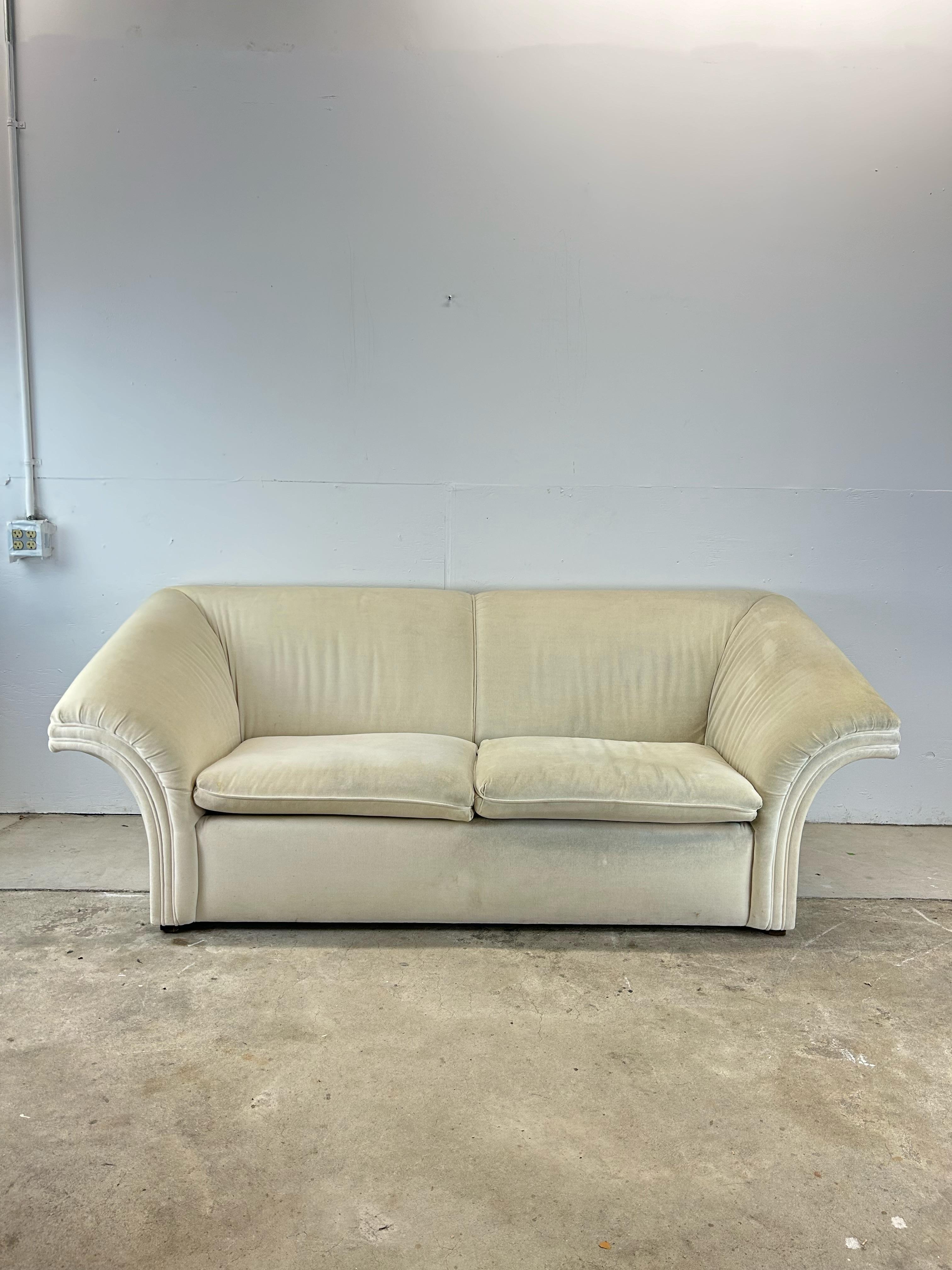 This postmodern sofa features vintage white upholstery, two removable cushions, and unique fluted back.   Check out our other complimentary postmodern seating & occasional table listings !
 Dimensions: 88w 39d 34h 30ah 17.5sh

Condition: Original