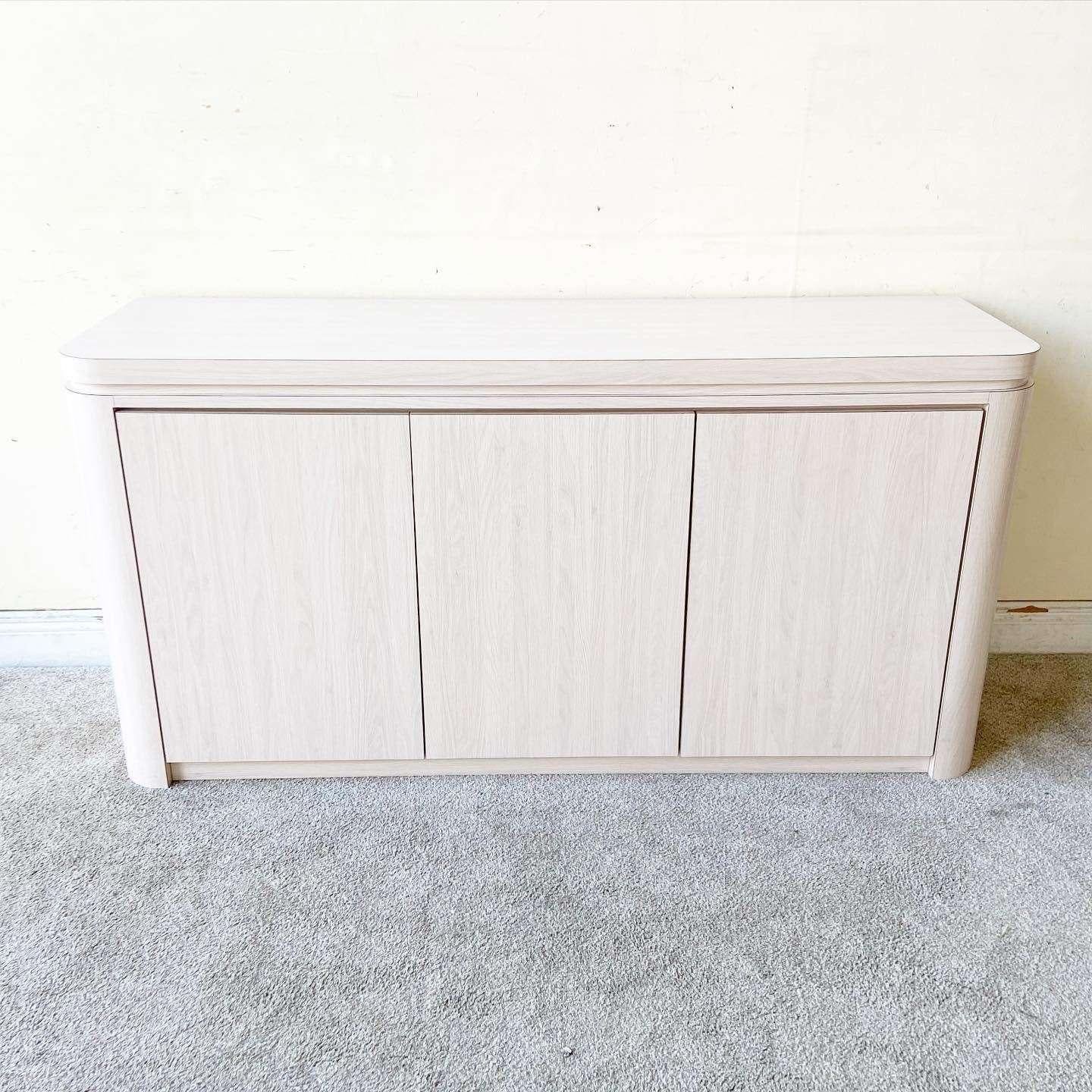 Wonderful vintage postmodern Woodgrain laminate credenza. Features three cabinet doors which click open to reveal ample storage.