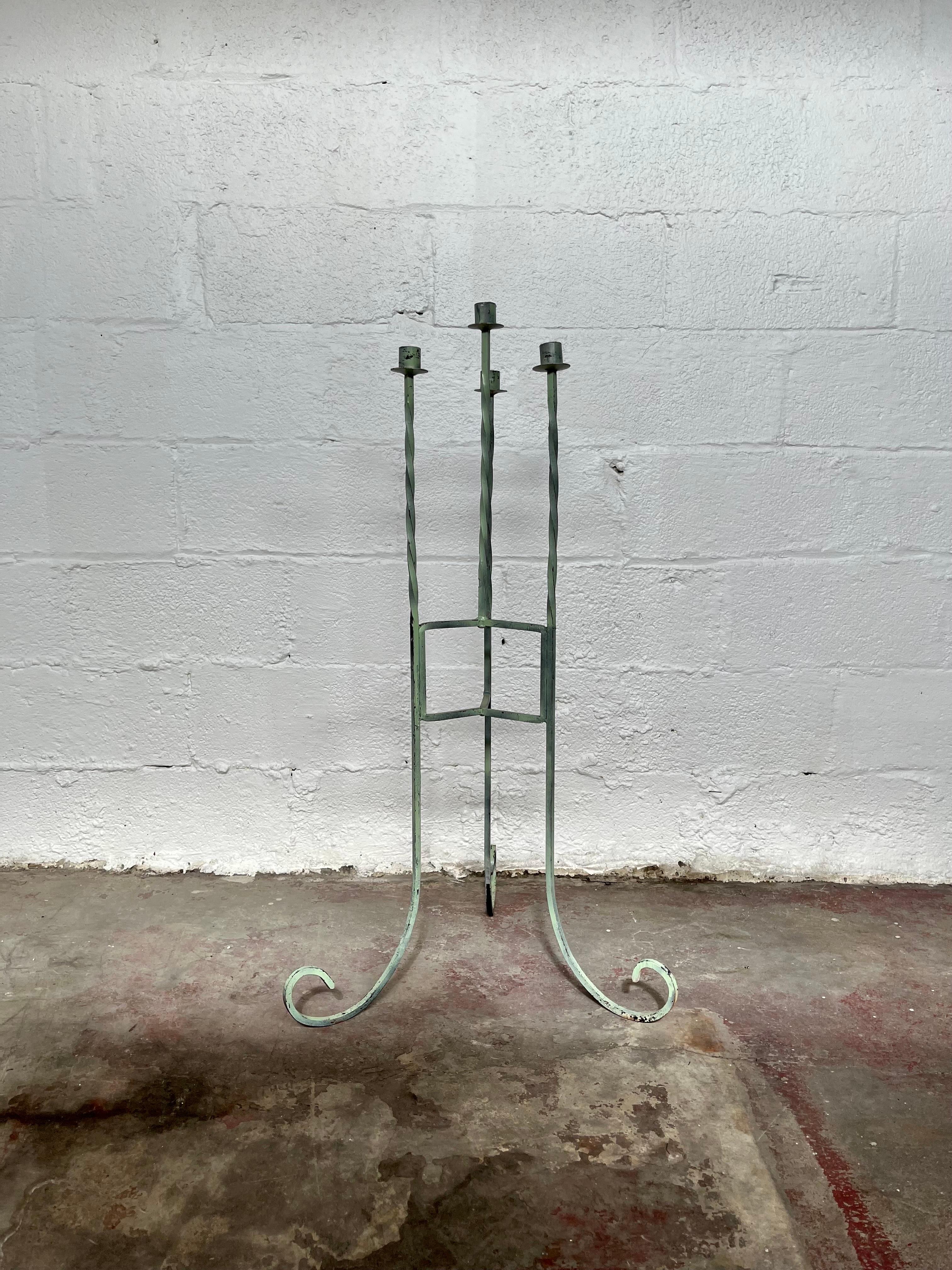 Postmodern floor candleabra with interesting twists and curves. Tall and sleek four candle holder. Painted wrought iron with upturned feet.