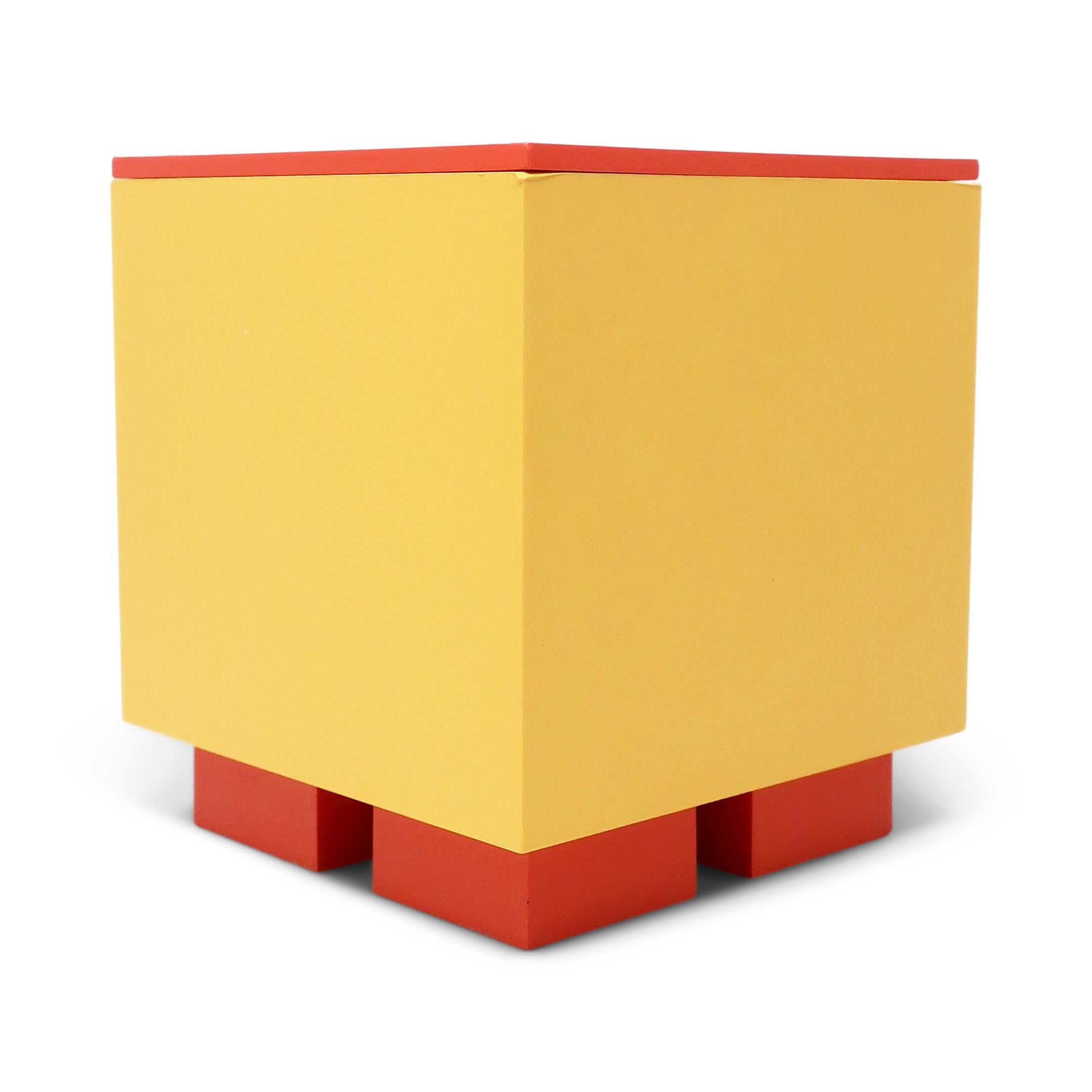 A classic design by Memphis Milano-affiliated American postmodern designer and architect Michael Graves for his Euclid line for Alessi, the Italian home goods powerhouse. A yellow body with orange lid sitting on orange rectangular feet.  Primary