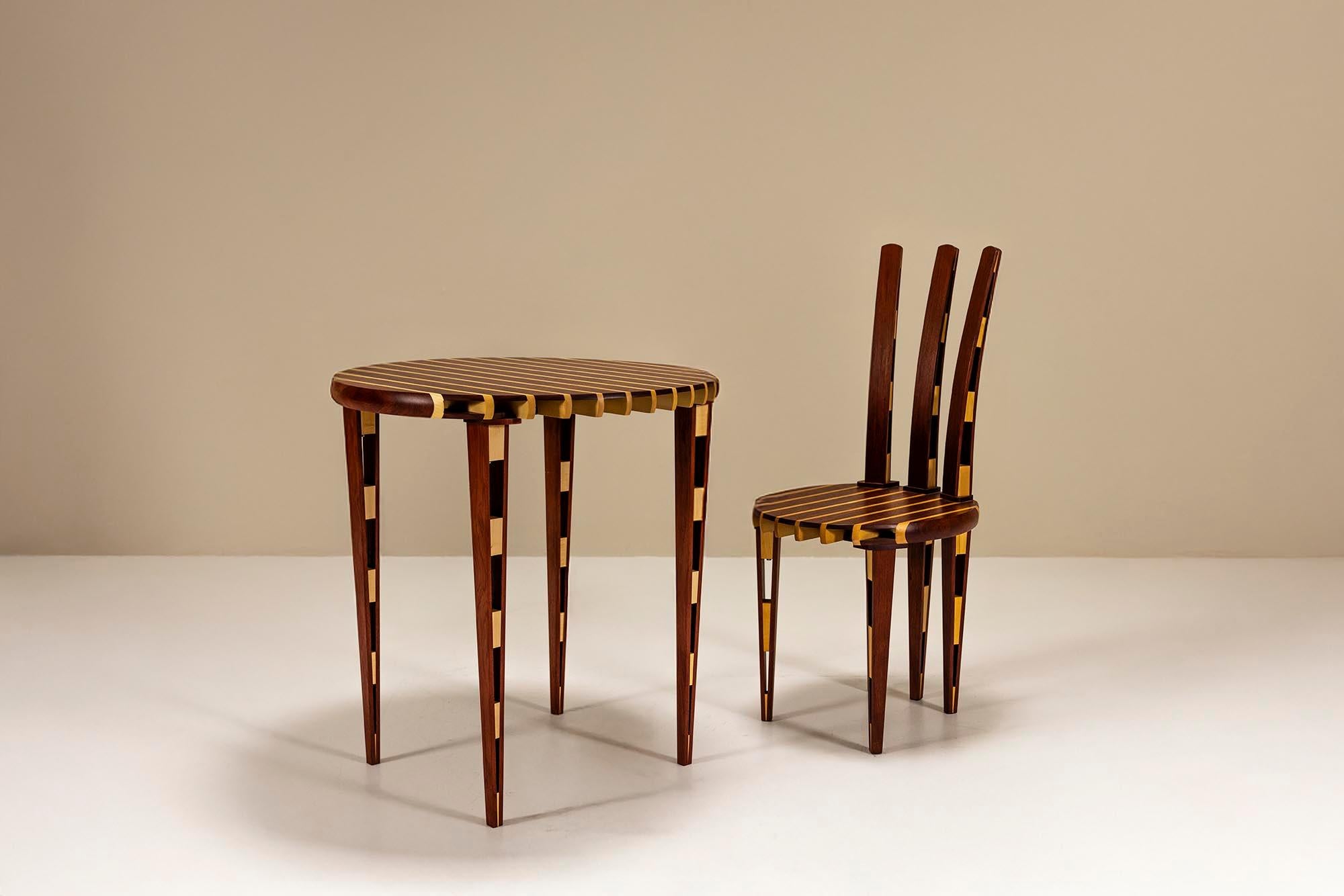 Dieses Tisch- und Stuhlset aus den 1990er Jahren ist ein kühnes Beispiel postmoderner Handwerkskunst. Es stellt Konventionen in Frage und zelebriert gleichzeitig Form und Material. Skulptural und funktional zugleich, bringt das Duo durch Rhythmus