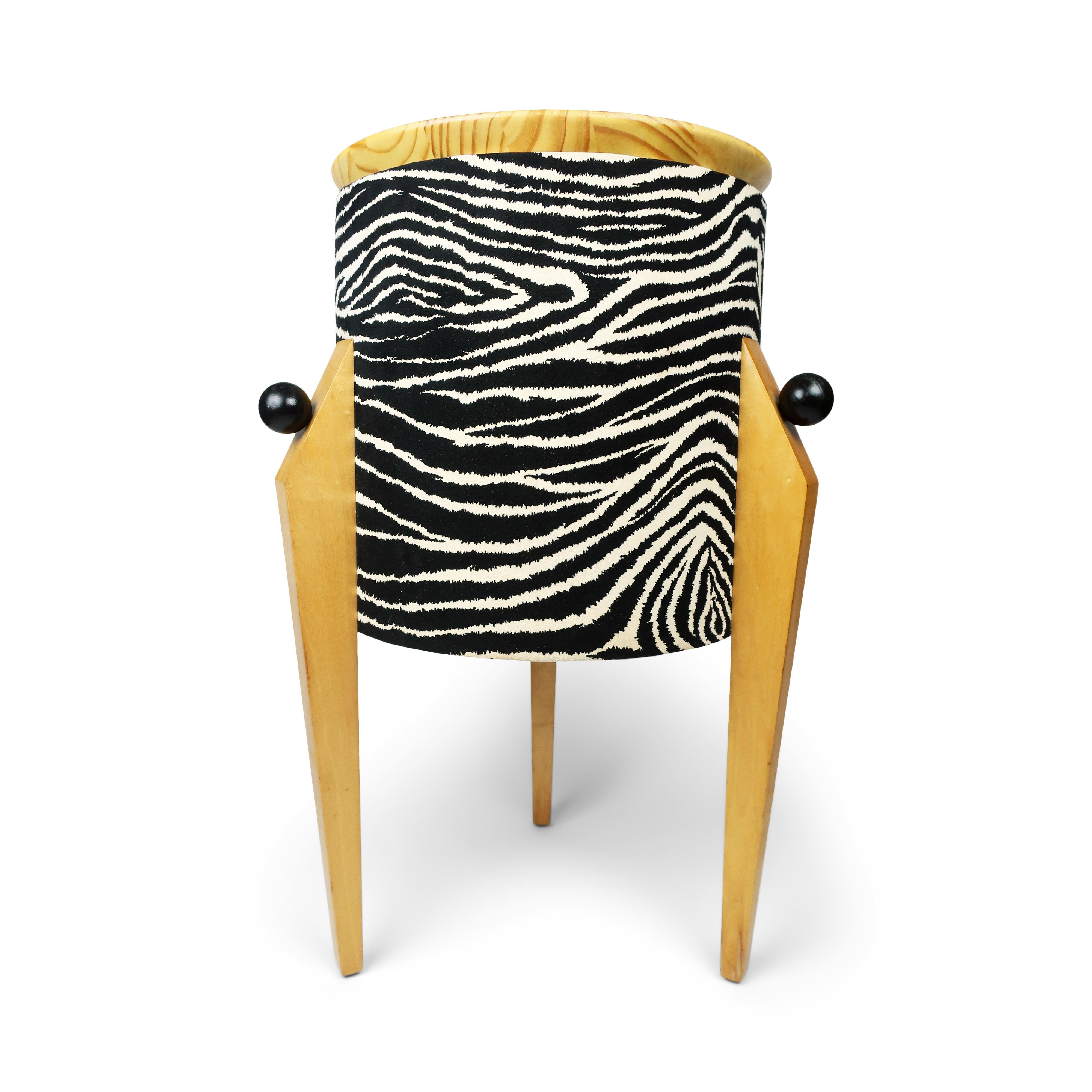 A striking 1980s postmodern side table with ight colored tripod legs, zebra print cylindrical body, black wooden ball accents, and light colored angled top. Might be Italian design and might be a one-of-a-kind studio piece. It is guaranteed to be