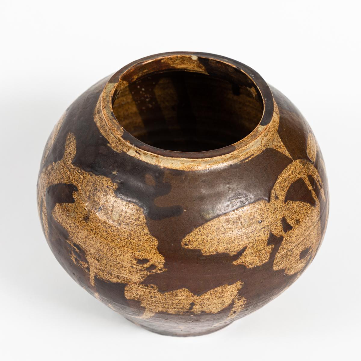 This is a small ceramic pot dating from turn of the century France. It features an abstract pattern in neutral tones of brown. It measures 7.5 in in diameter and 6.5 in tall. 