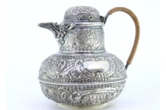 Pot-shaped silver milk jug with relief and monogram card, stuffed handle