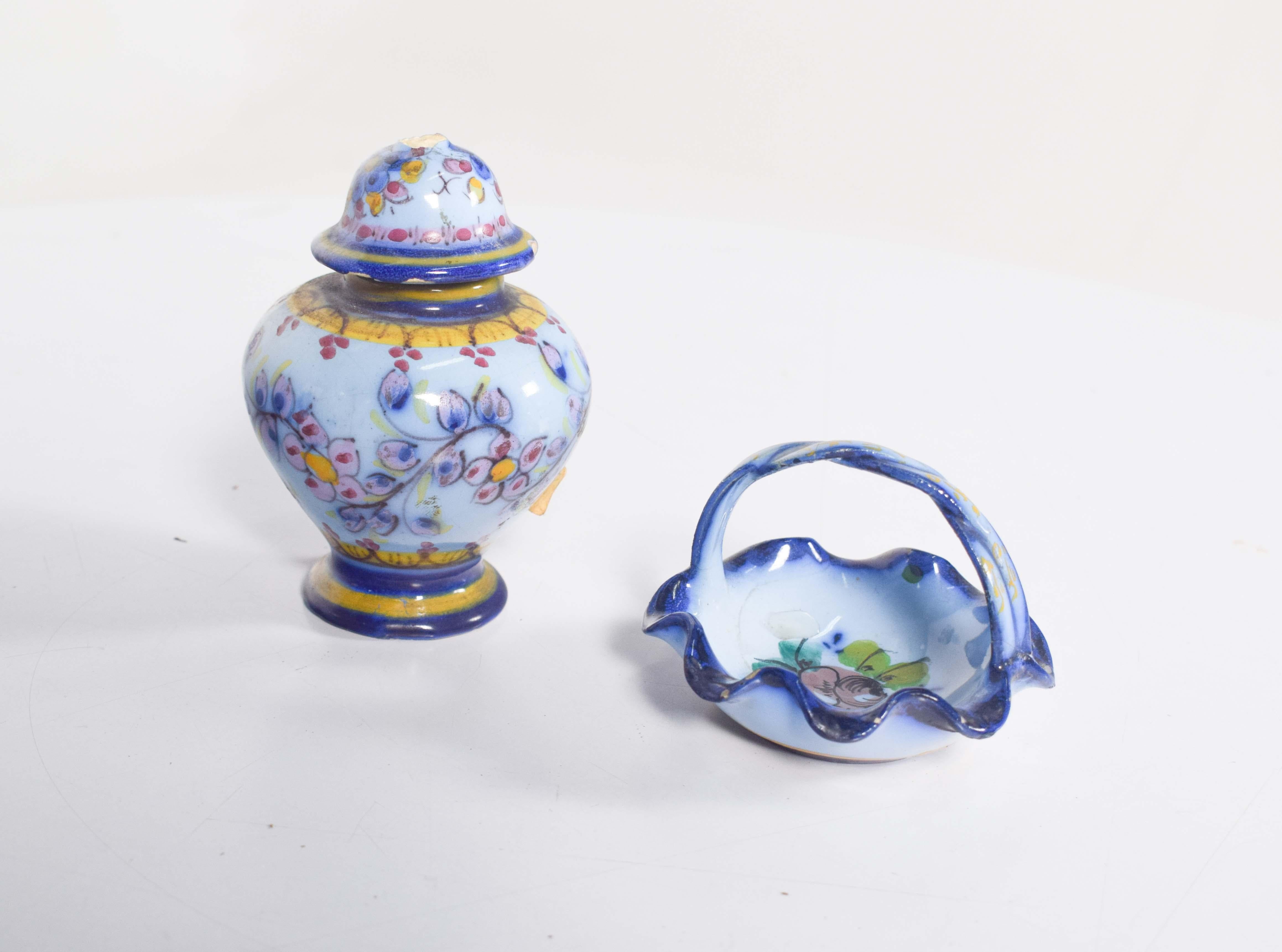 Questo affascinante set di ceramiche portoghesi di Alcobaça è composto da un vaso con coperchio e da un piccolo cesto con manico decorativo, entrambi con la caratteristica decorazione policroma e vivace della regione. Il vaso ha una forma bulbosa