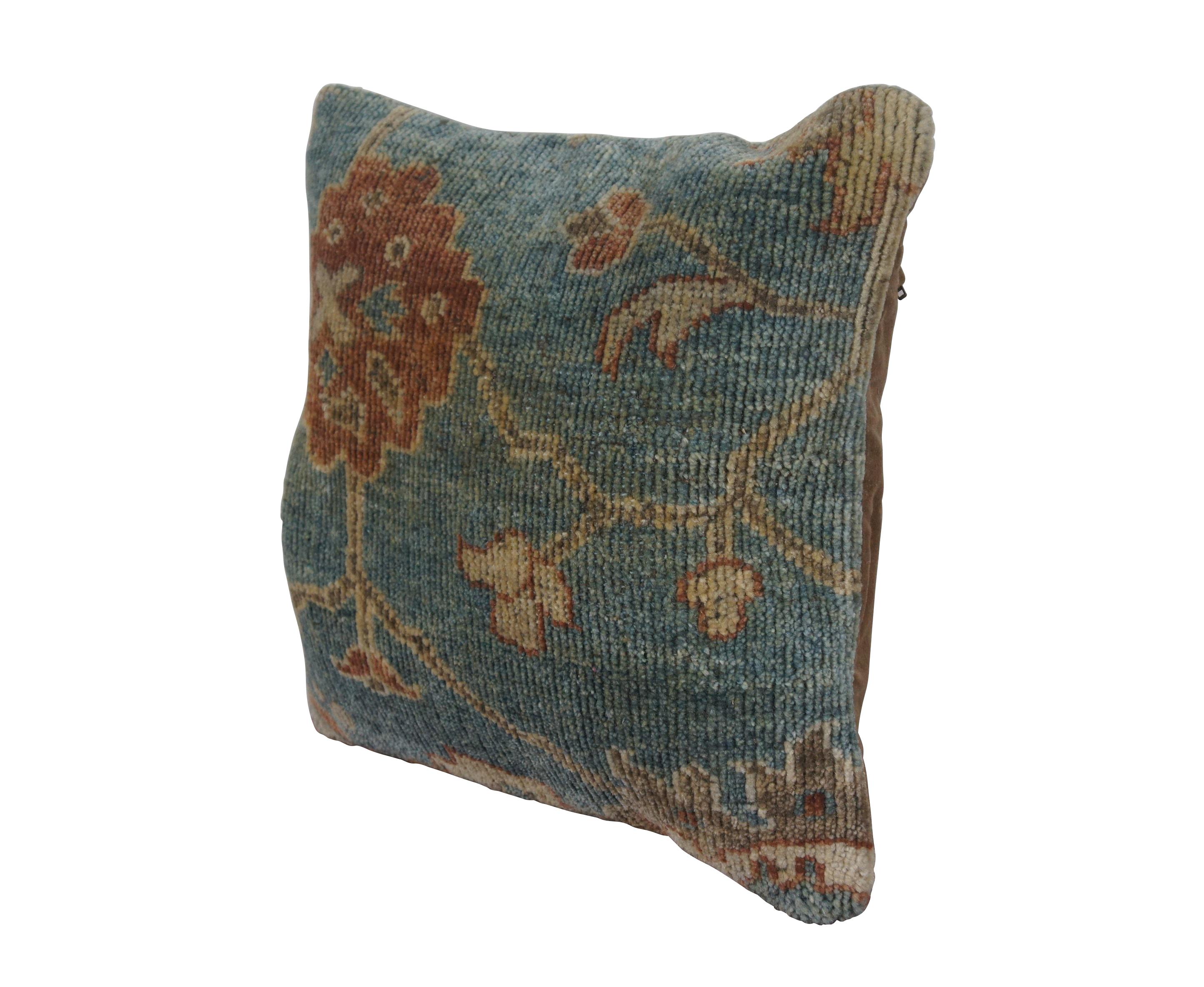 Late 20th century square throw pillow by Pottery Barn, featuring a wool and cotton carpet inspired floral design in brown and orange on a blue background. Brown cotton velour back with zipper closure. Down filled. Made in India.

Dimensions:
18
