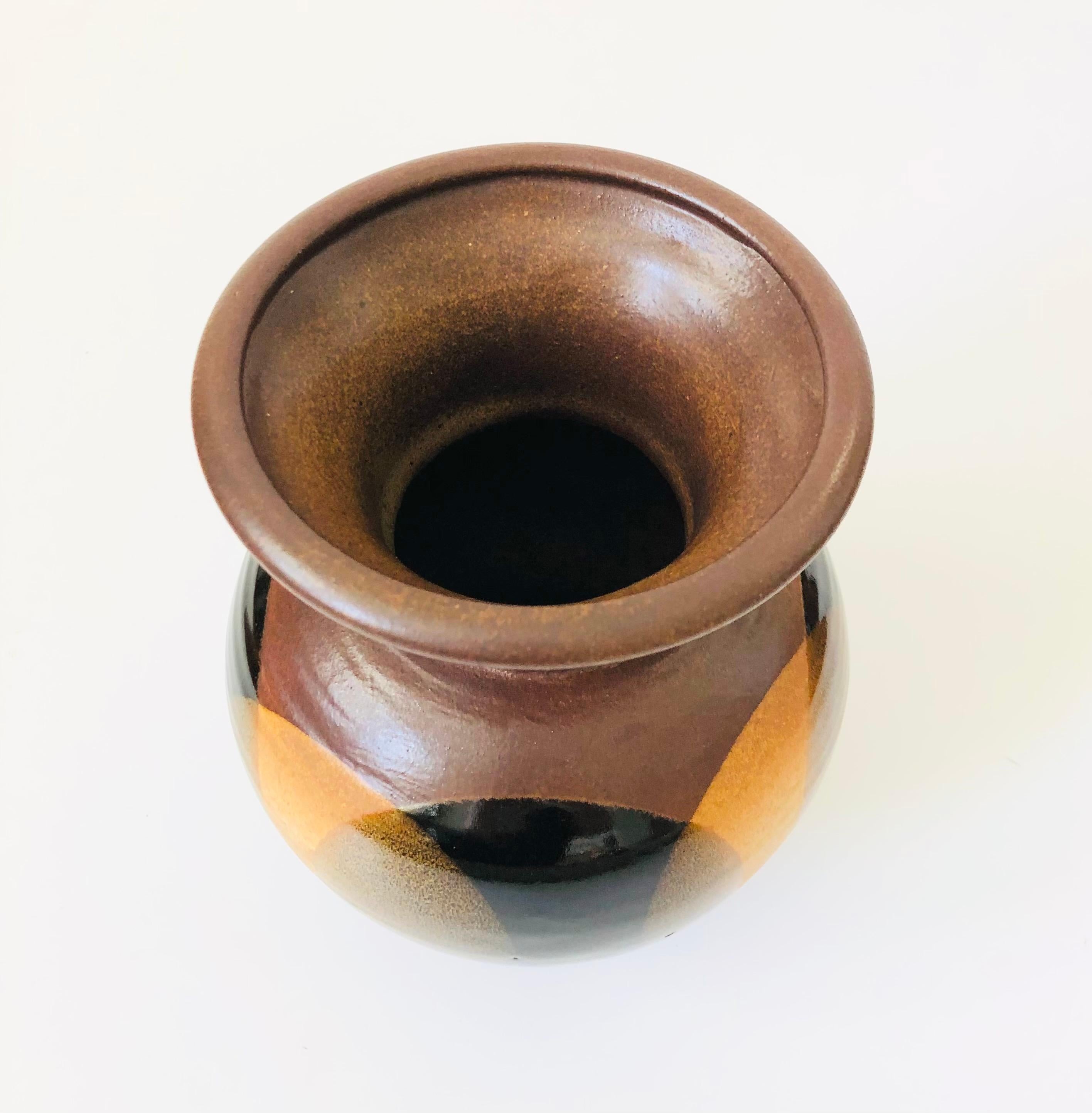 Magnifique vase du milieu du siècle conçu par Robert Maxwell pour Pottery Craft. La glaçure est ornée d'un motif de cercles superposés en brun et noir.

