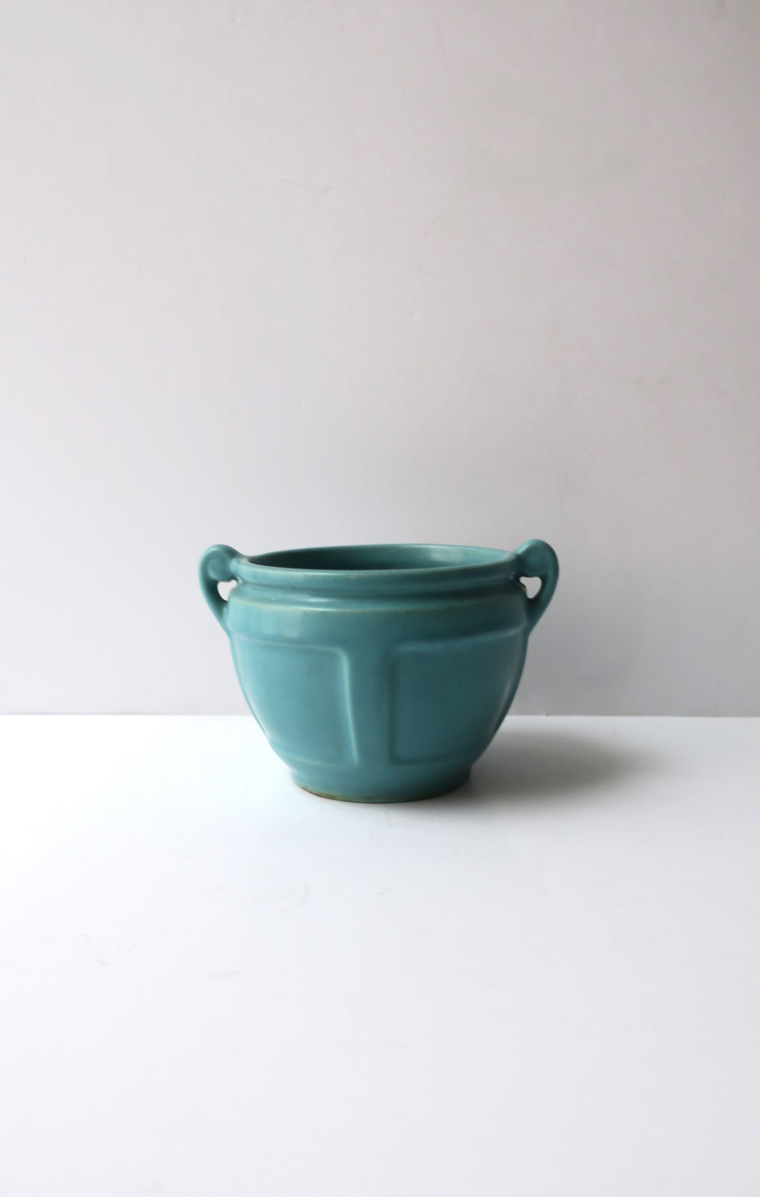 A turquoise urn-style pottery flower or plant pot planter cachepot jardinière, circa early-20th century. A beautiful small urn-like turquoise blue pottery planter with detailed front/back and scrolled handles on sides. Dimensions: 4.88