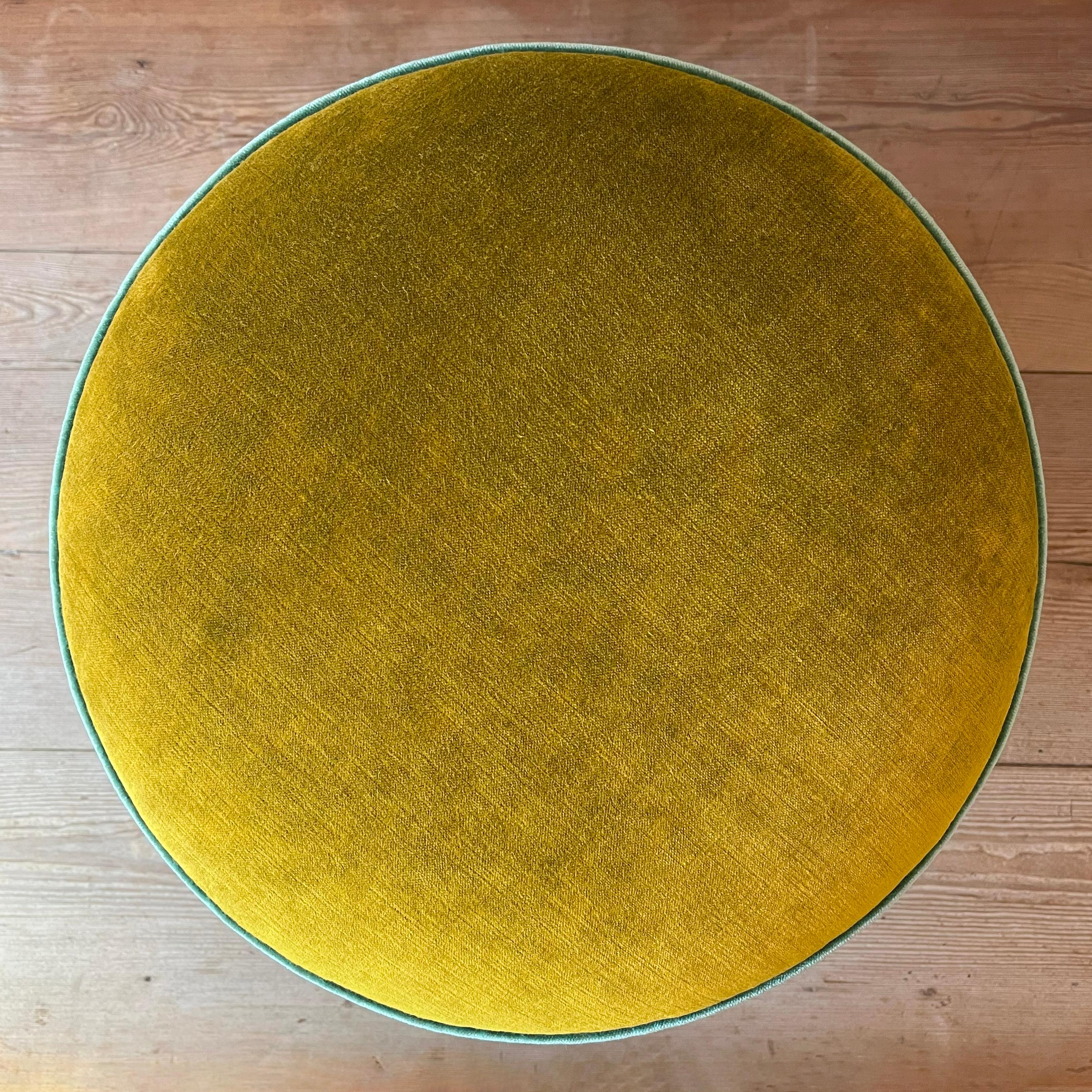 Un pouf come un piccolo gioiello domestico: verde, azzurro e un accento di beige si intrecciano in una palette all’insegna dell’eleganza e dell’artigianalità. 
Il design è composto da tre parti assemblate con interno in legno e imbottitura