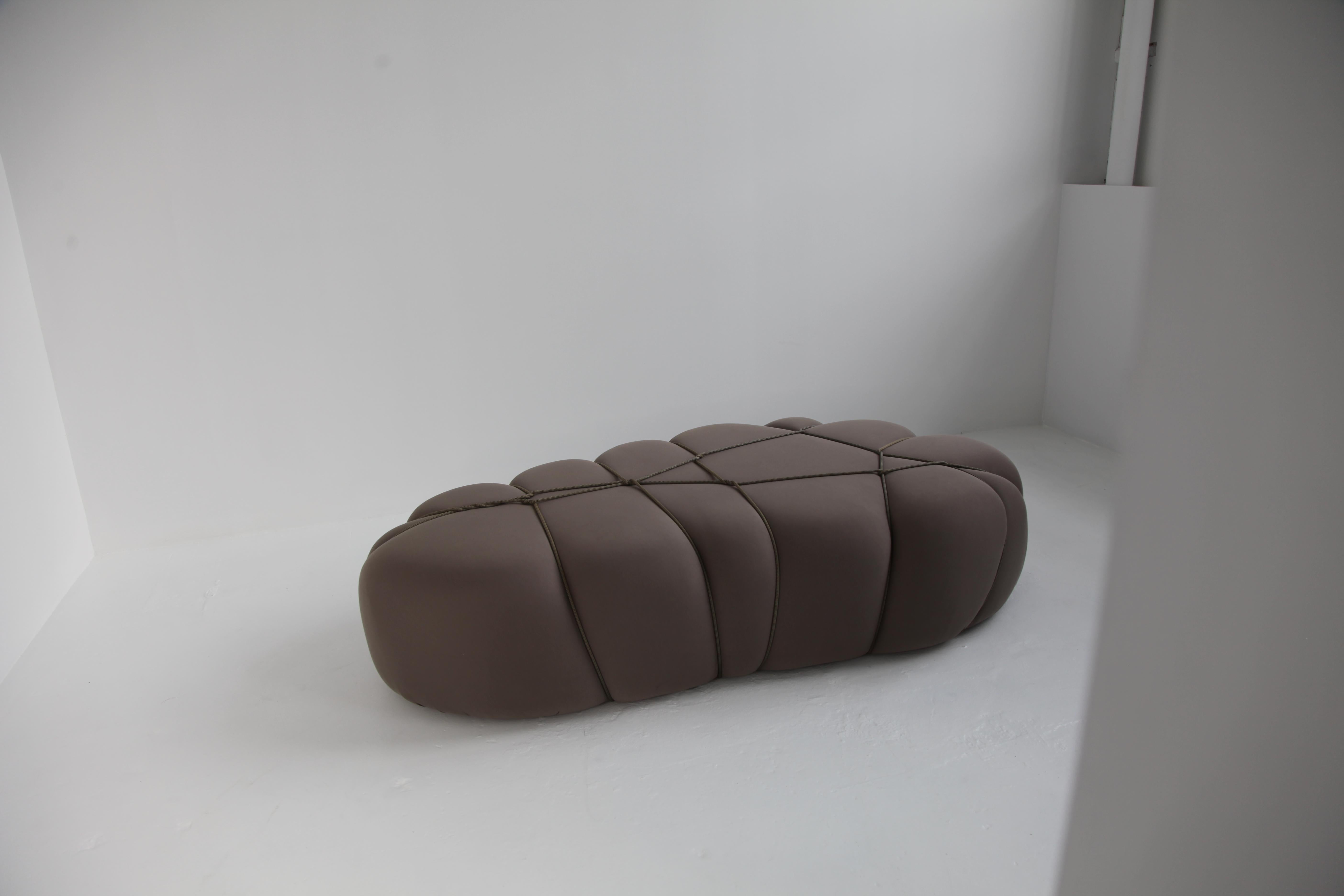 The poufs are a form of modular furniture designed for both relaxation and seating. They are constructed from soft foam covered with a thick, elastic fabric that conceals any visible seams. Drawing inspiration from the intricate art of Shibari, a