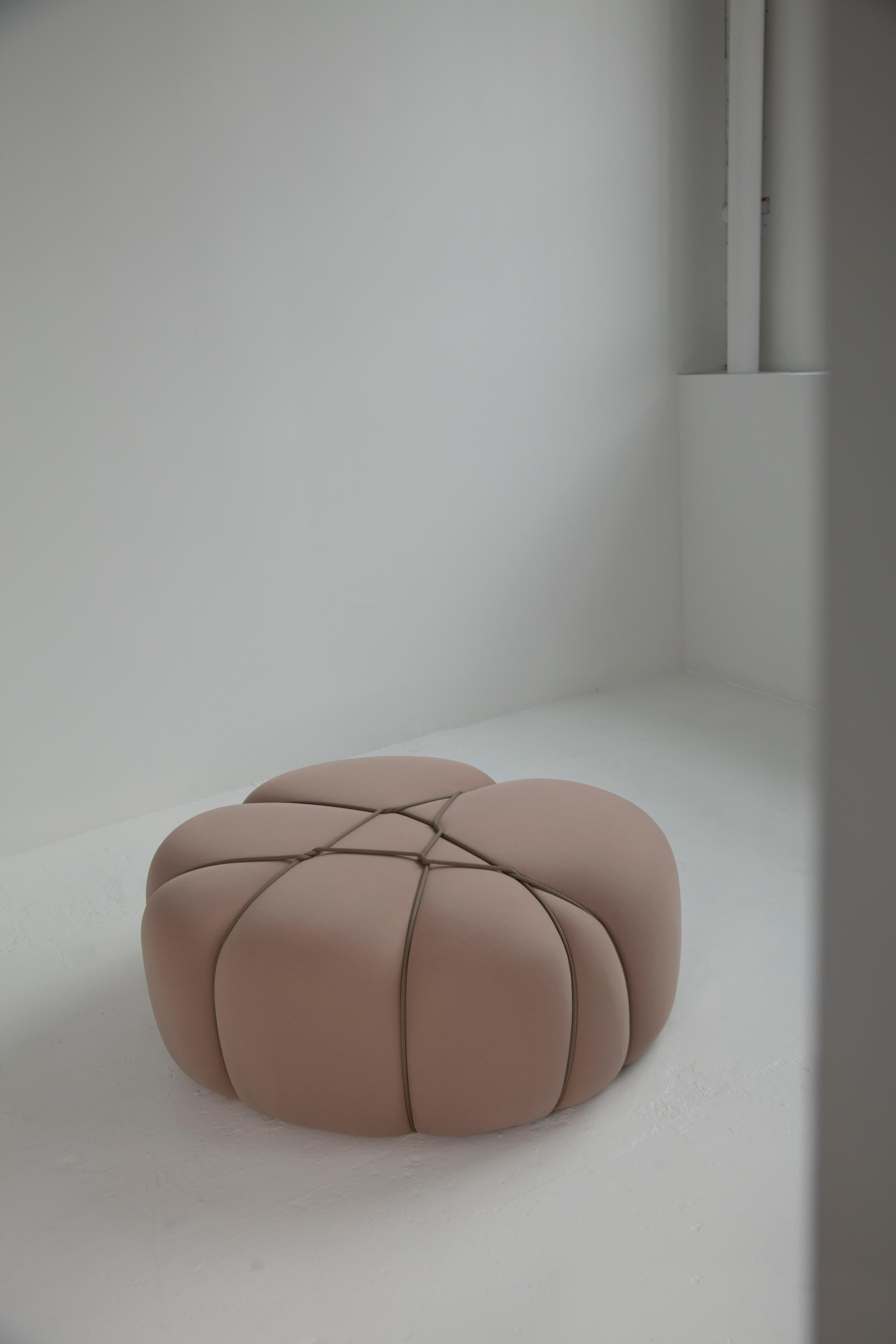 The poufs are a form of modular furniture designed for both relaxation and seating. They are constructed from soft foam covered with a thick, elastic fabric that conceals any visible seams. Drawing inspiration from the intricate art of Shibari, a