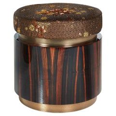 Pouf in Polished Ebony Finish Top in Fabric and Decorative Liquid Metal Edges Pouf in Polished Ebony Finish Top in Fabric and Decorative Liquid Metal Edges