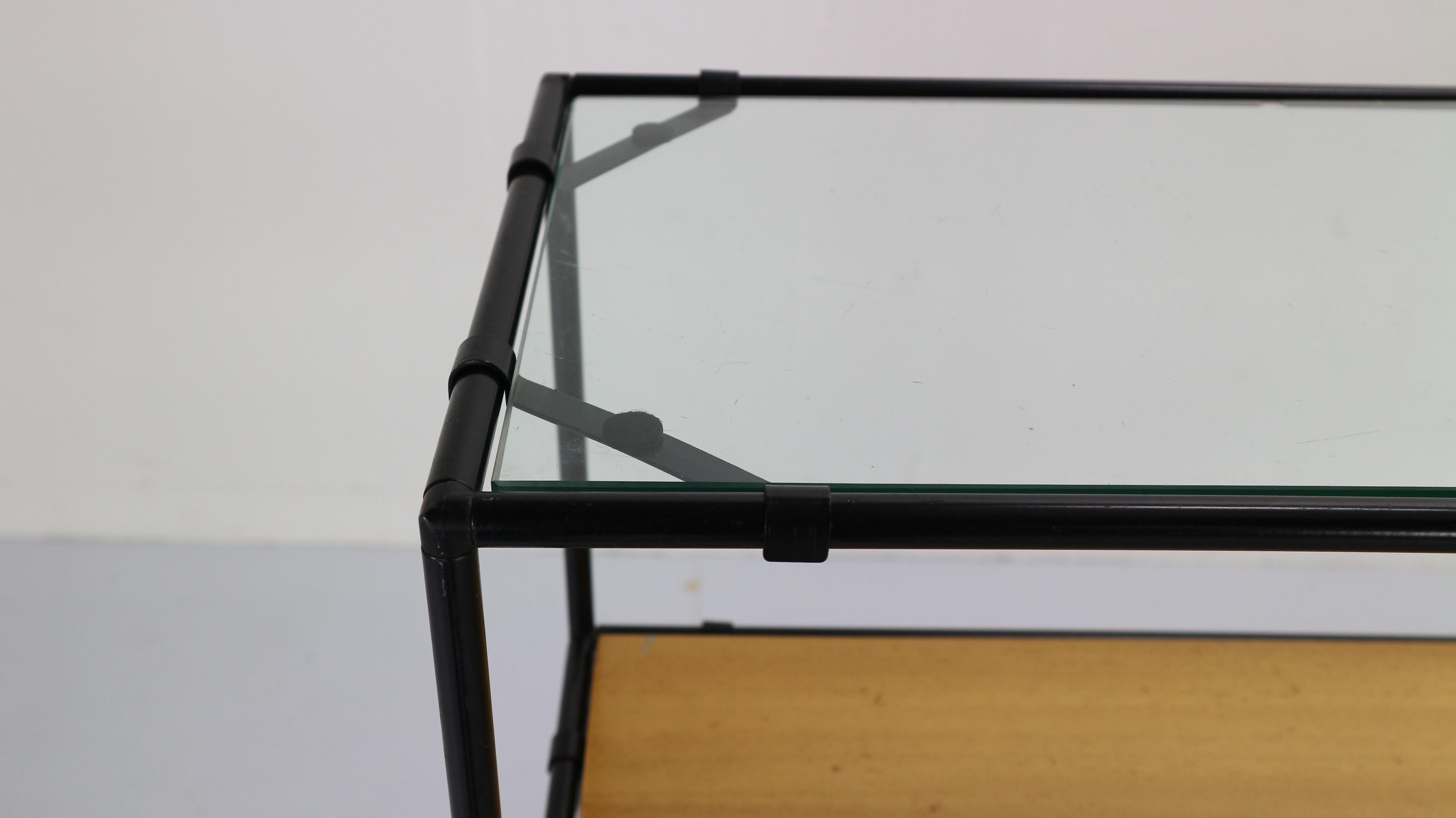 Minimalist shelving unit designed by and produced by Royal System, Denmark, circa 1960. This modular system exists of black metal tubes with connectors, floating birch wooden and glass shelves.
 