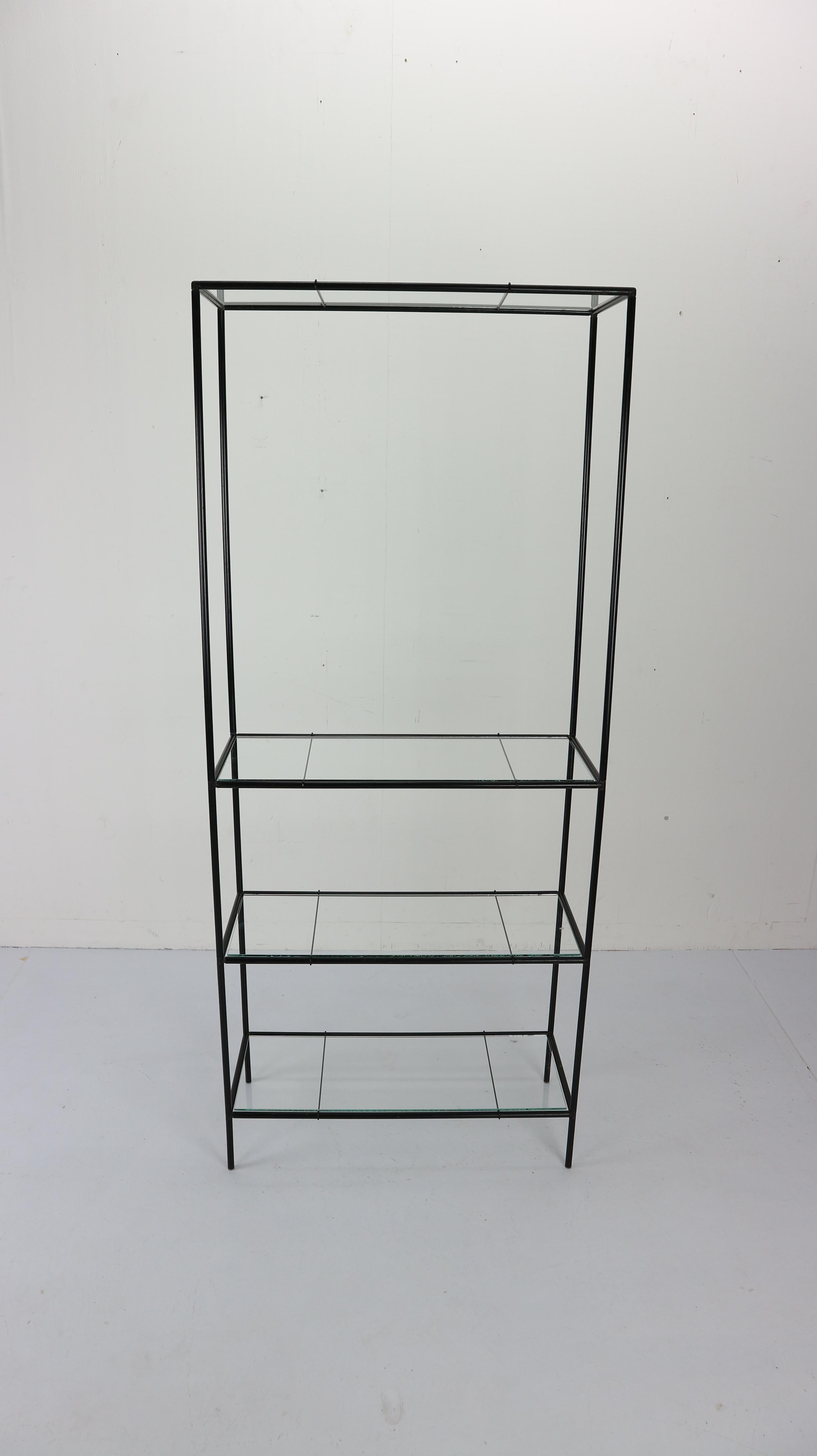 Minimalist shelving unit designed by and produced by Royal System, Denmark, circa 1960. This modular system exists of black metal tubes with connectors, floating glass shelves. 
  