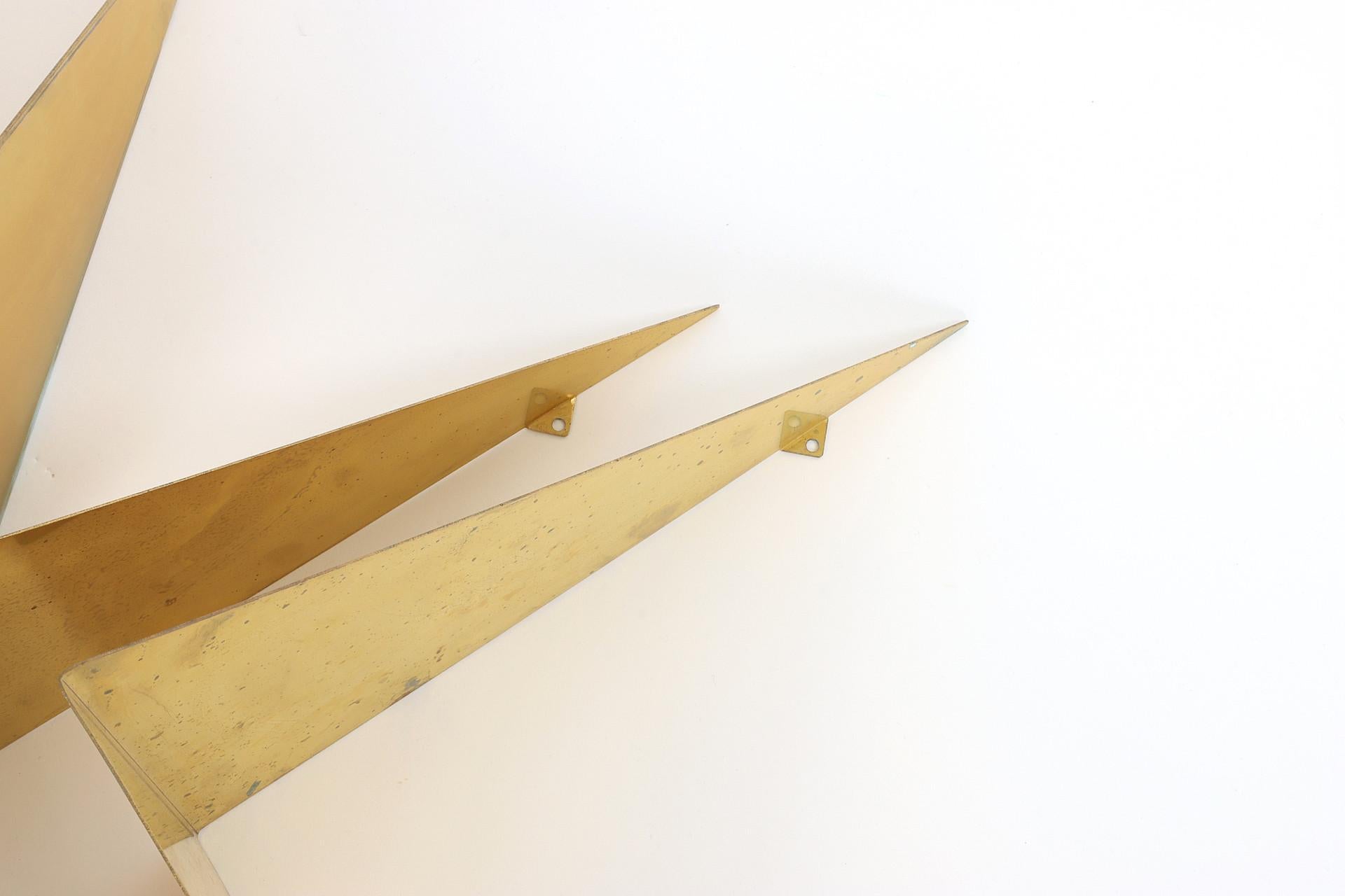 Étagères murales fabriquées par le designer danois Poul Cadovius en 1960 Elles peuvent être suspendues de différentes manières et peuvent également être utilisées uniquement à des fins décoratives. Rare édition en laiton. Set de 6 étagères 
Bon état