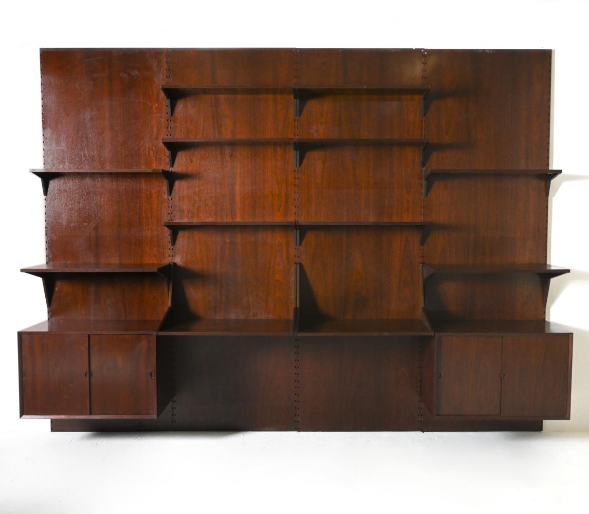 Immerse yourself in the epitome of mid-century Danish design with this breathtaking wall unit, brilliantly conceived by the legendary Poul Cadovius for Cado. A harmonious fusion of functionality, art, and timeless elegance, this piece stands as a