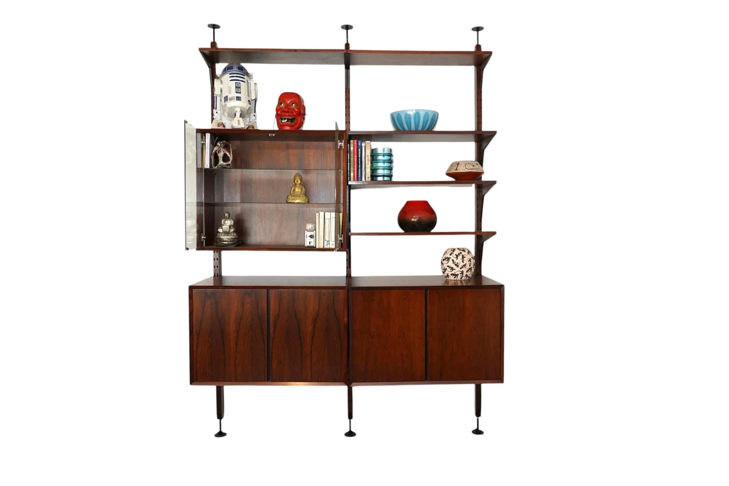 A rare and beautifully refinished rosewood shelving unit by Poul Cadovius, part of the iconic Royal System, designed in the 1960s. This freestanding unit is tension-mounted between the floor and ceiling, making it both functional and visually