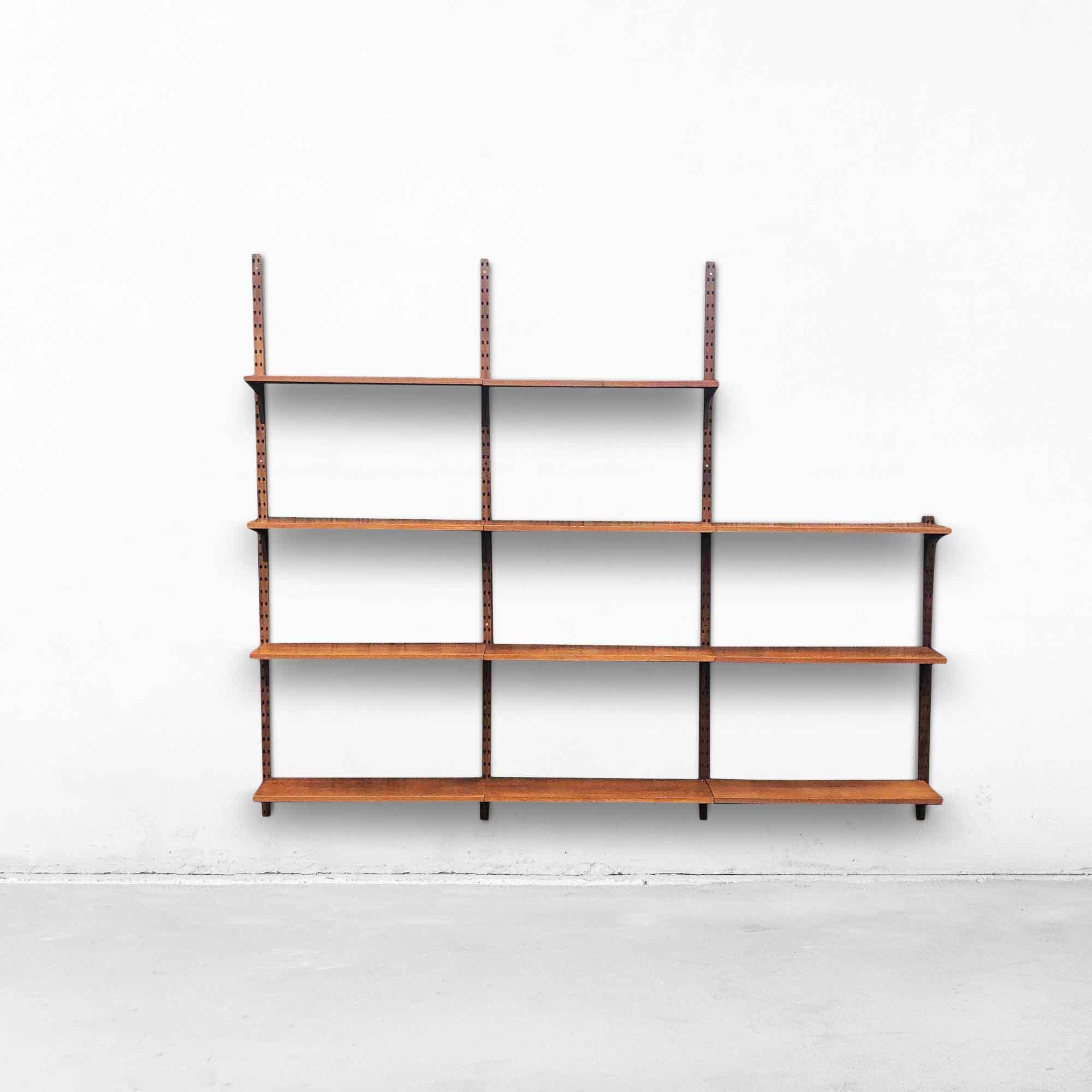 Modular wall system by Danish designer Poul Cadovius for CADO from the 1960s. This piece of furniture is made of walnut and the planks and supports can be rearranged in various ways as desired. The wall system consists of 11 shelves, 3 high