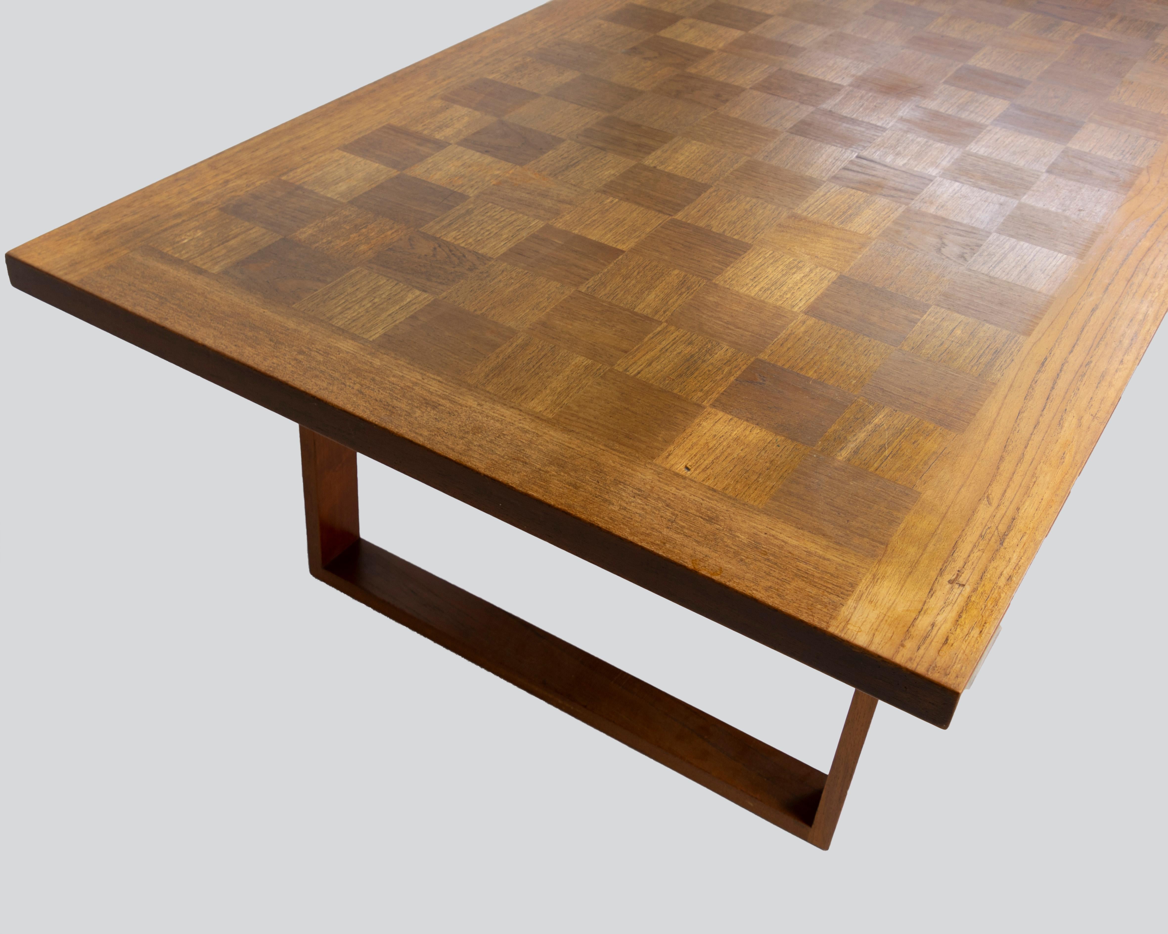 Large coffee table, sometimes called Boggie Woogie chess tables. This teak parquet table sits on two sled legs. Rectangular model with its metallic label of the numbered and embedded mark on the back of the board. 

Poul Cadovius (September 27,