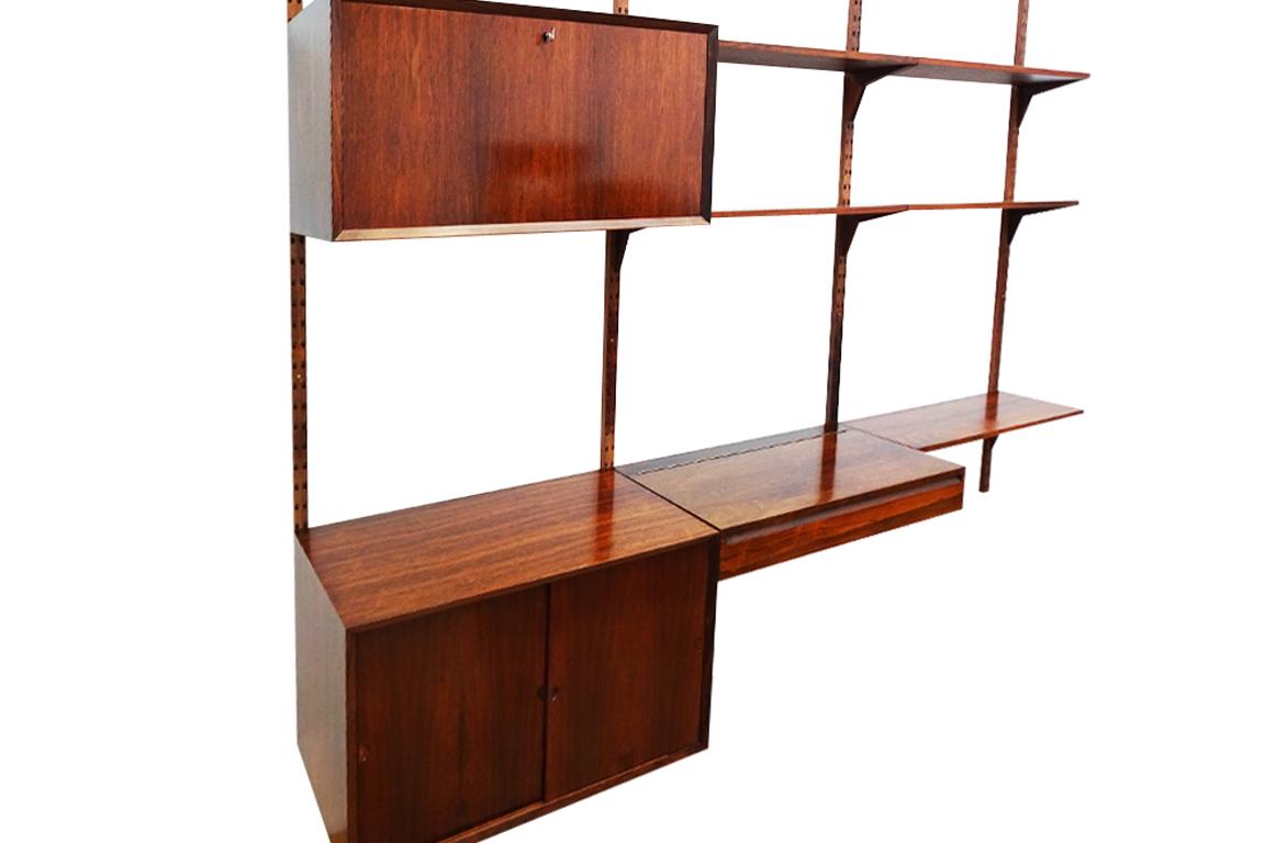 A Danish Mid-Century Modern rosewood Royal System floating wall and shelving set designed by Poul Cadovius for Cado. 

This is a very adaptable set as it comprises 4 wall support ‘strings’ so you can either spread the units and shelves out over a