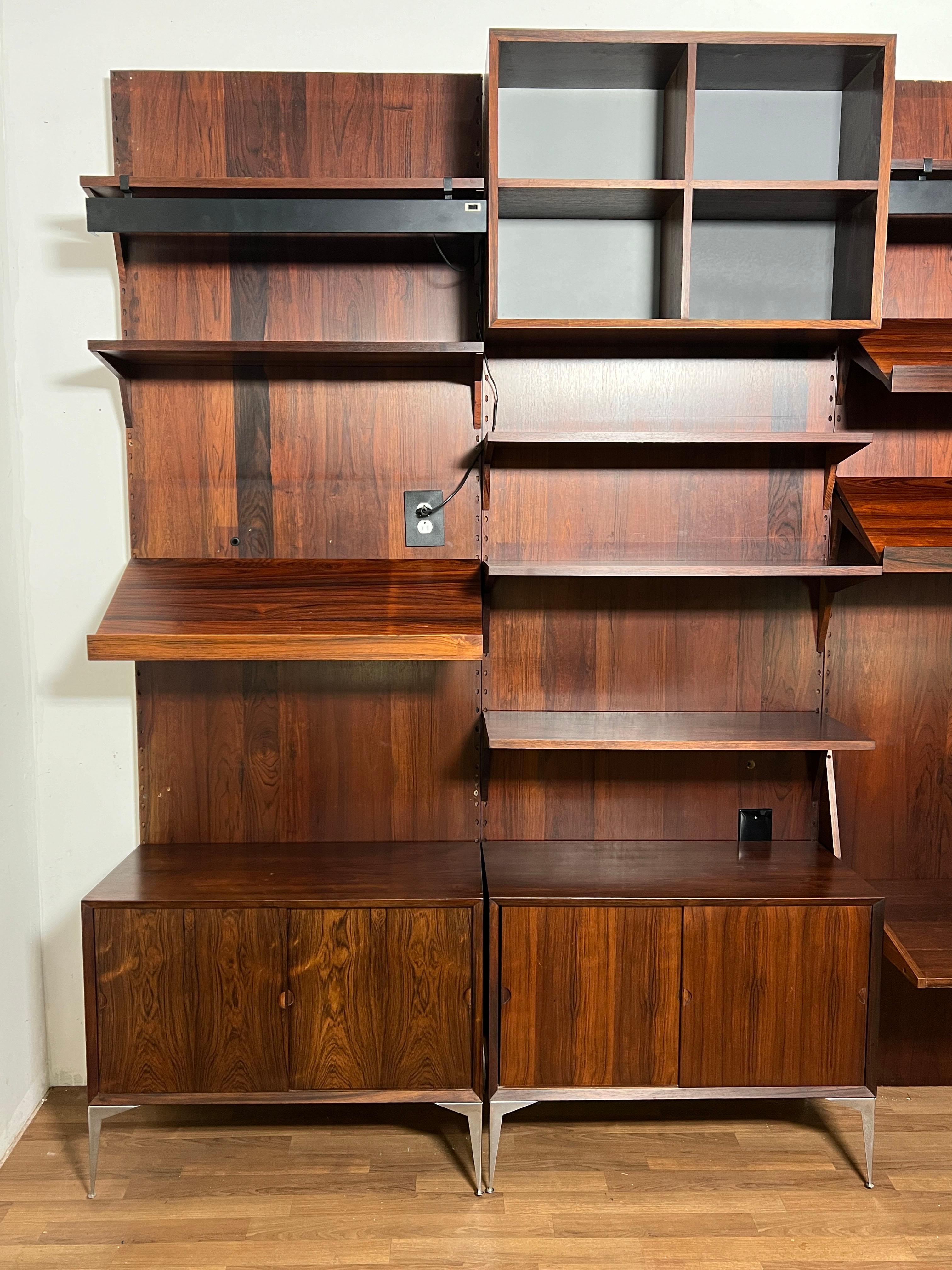 Royal System “Cado” four bay wall unit in rosewood, designed by Poul Cadovius circa 1960s, Denmark. Purchased by prior owner in 1973. It features floor to ceiling wall panels, floor cabinets and numerous shelving options including a television