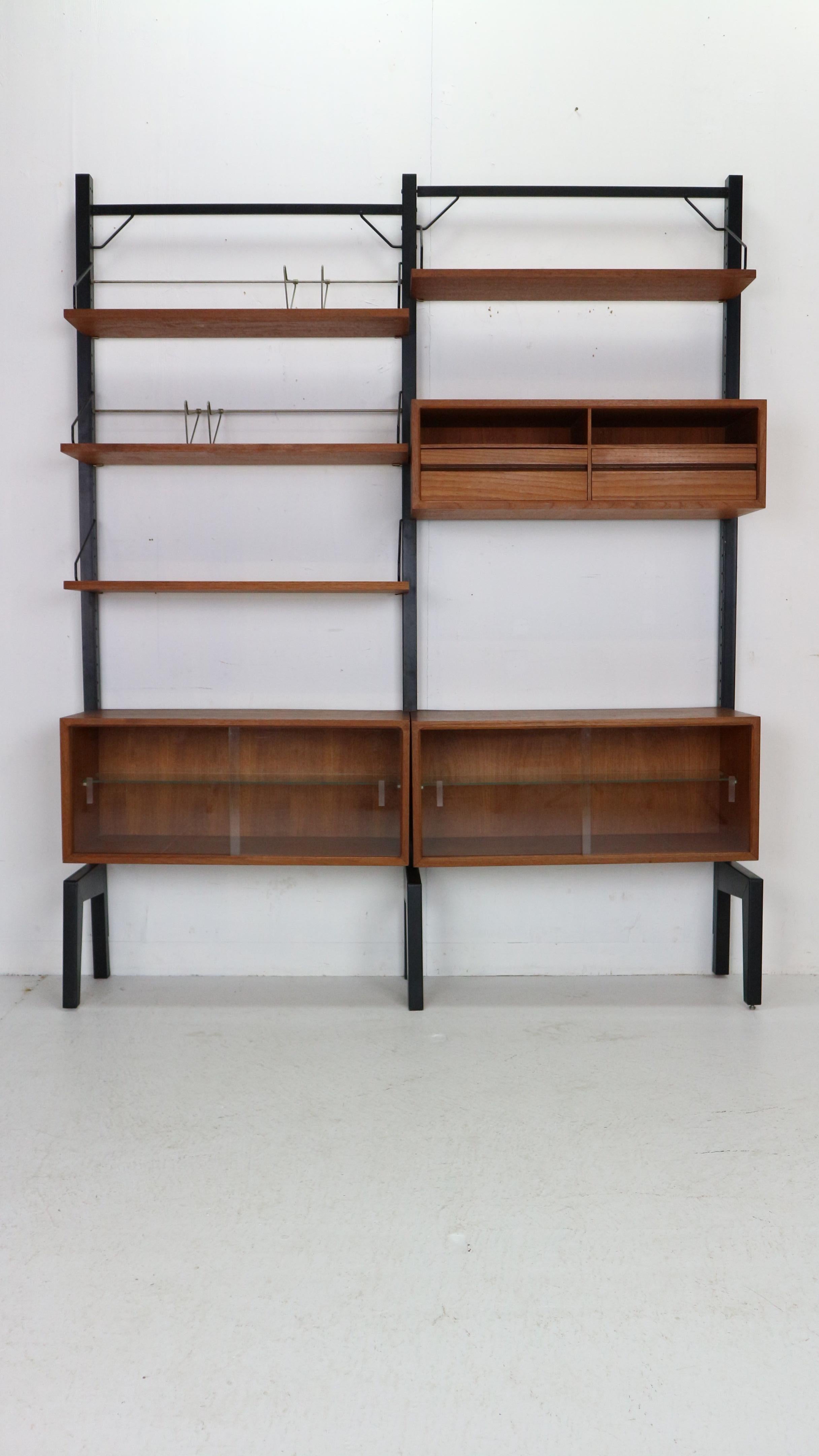 Original freestanding wall unit designed by Poul Cadovius, model Royal, in the 1960s for Royal System, Denmark.
Freestanding wall unit consists 3 black metal standers, teak veneer four shelves, two glass cabinets, one cabinet with drawers and two