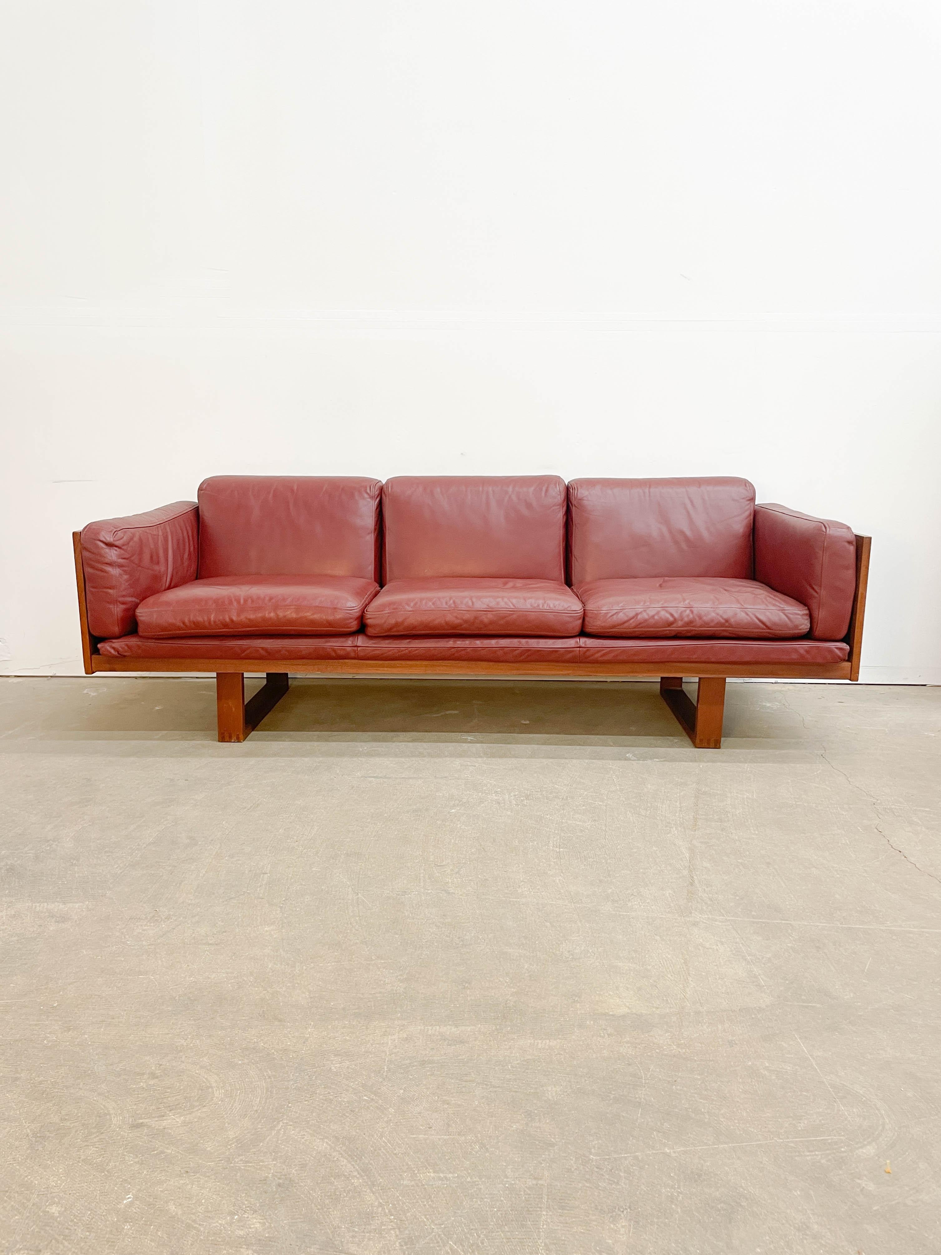 A Danish modern classic, this teak frame sofa with basket weave panels and leather cushions was designed in the 1960s by Poul Cadovius for France and Son. This sofa offers superb contrast between its angular sled legs, unique woven wood texture