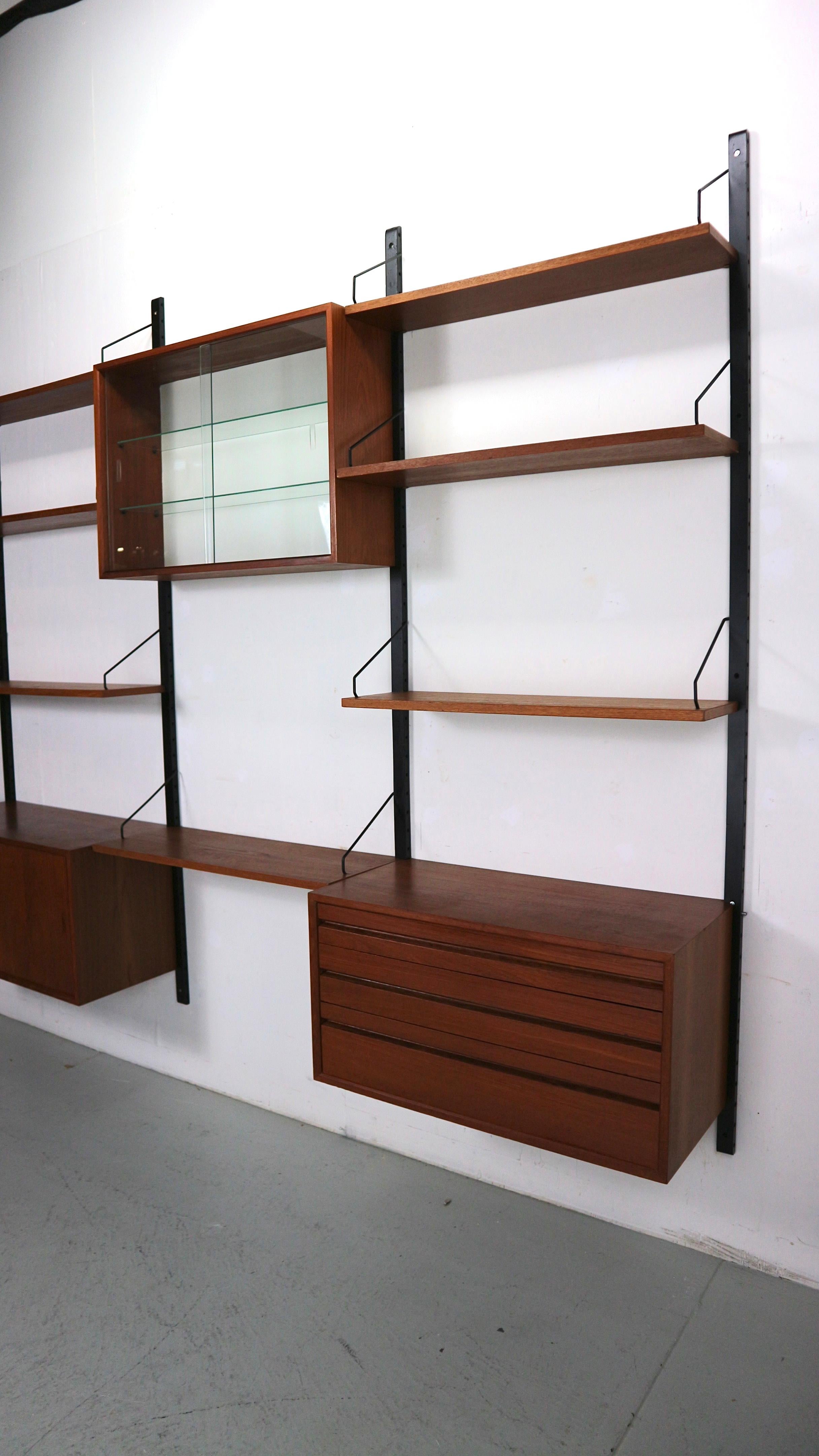 Danish modern teak wall unit designed by Poul Cadovius, Denmark, circa 1960s.

This piece is contains 7  shelves and one sliding door cabinet, a drawer cabinet and a display cabinet.

This piece is completely adjustable, and any of the case pieces