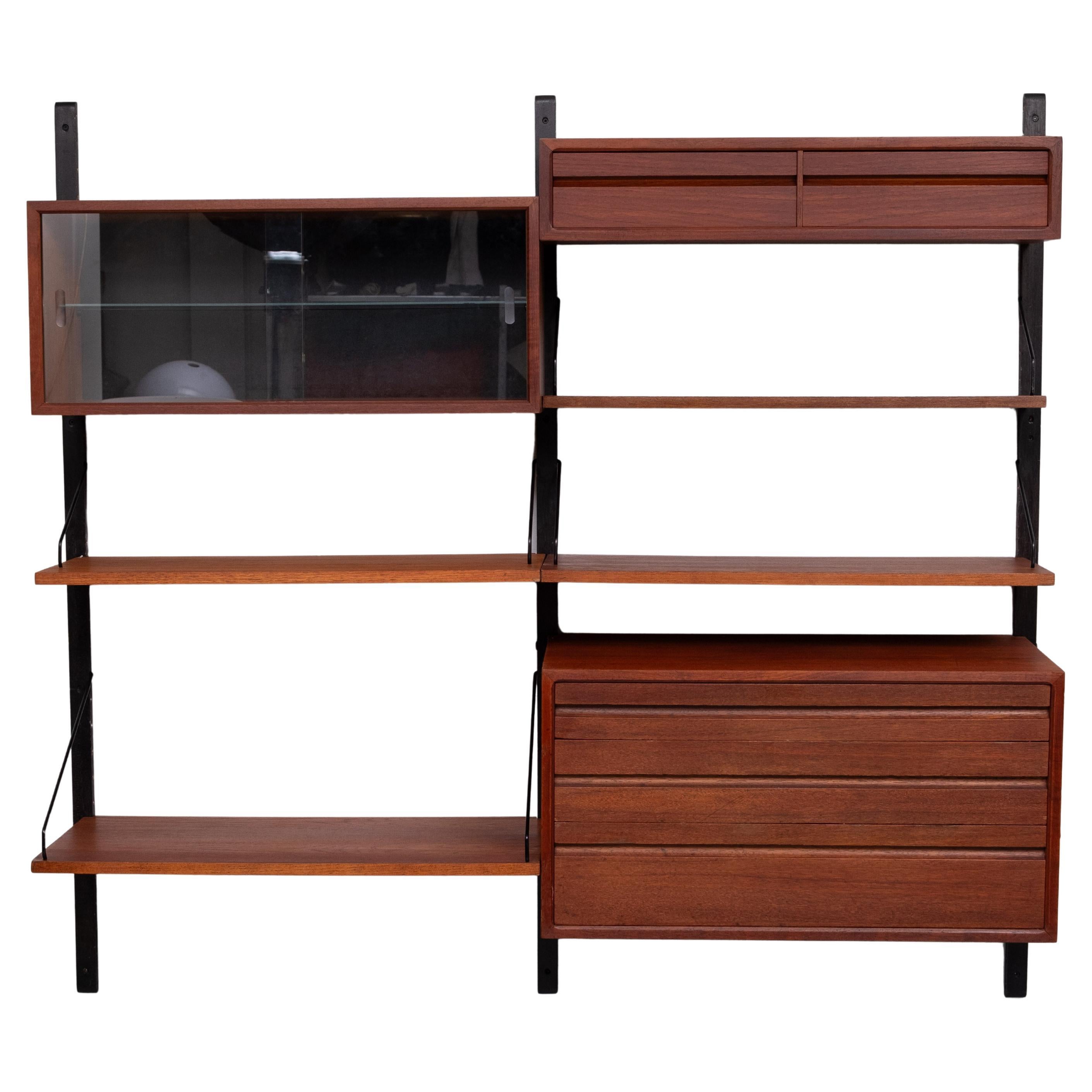Poul Cadovius Royal Wall system 1960s Danimarca .composto da . 3 montanti 
Tre armadietti. Una vetrina con ante in vetro, una vetrina grande con tre cassetti e una vetrina piccola con due cassetti.  Un grande scaffale per la scrittura.
Altri 3